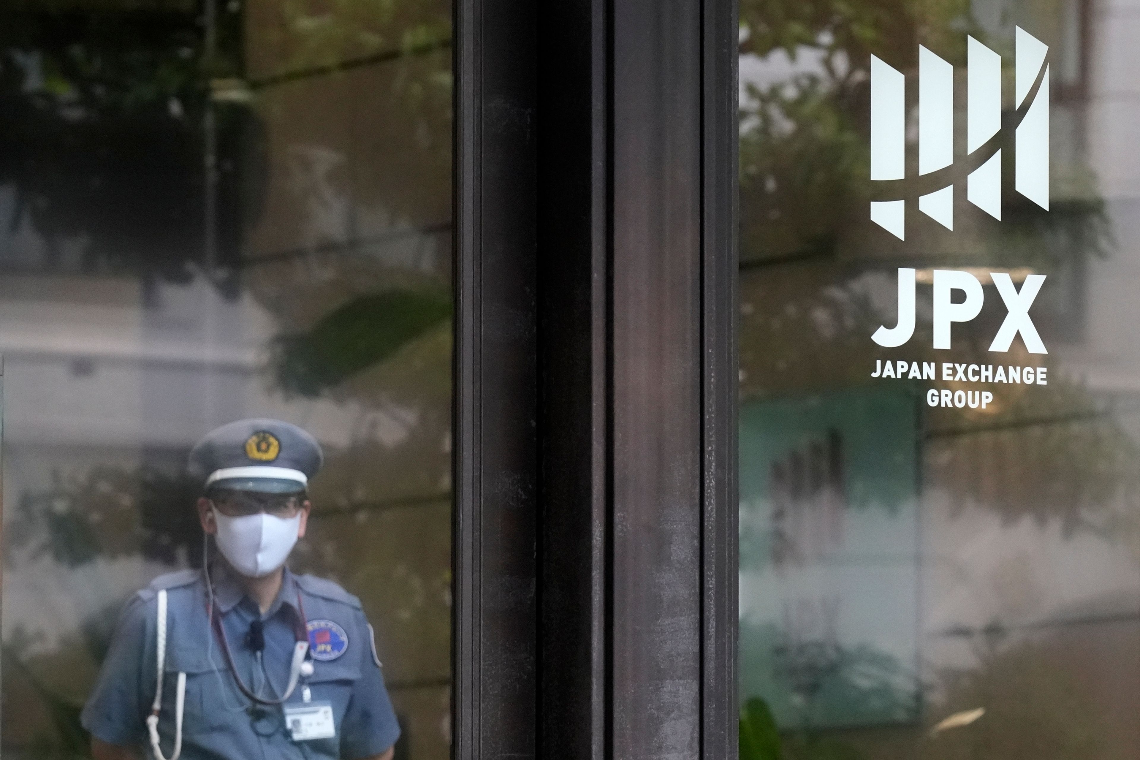 FILE - A security guard stands guard at the entrance of Tokyo Stock Exchange building in Tokyo, on May 28, 2024. Asian shares traded mixed Wednesday, June 5, 2024, as investors weighed recent data highlighting a slowing U.S. economy that offers both upsides and downsides for Wall Street.