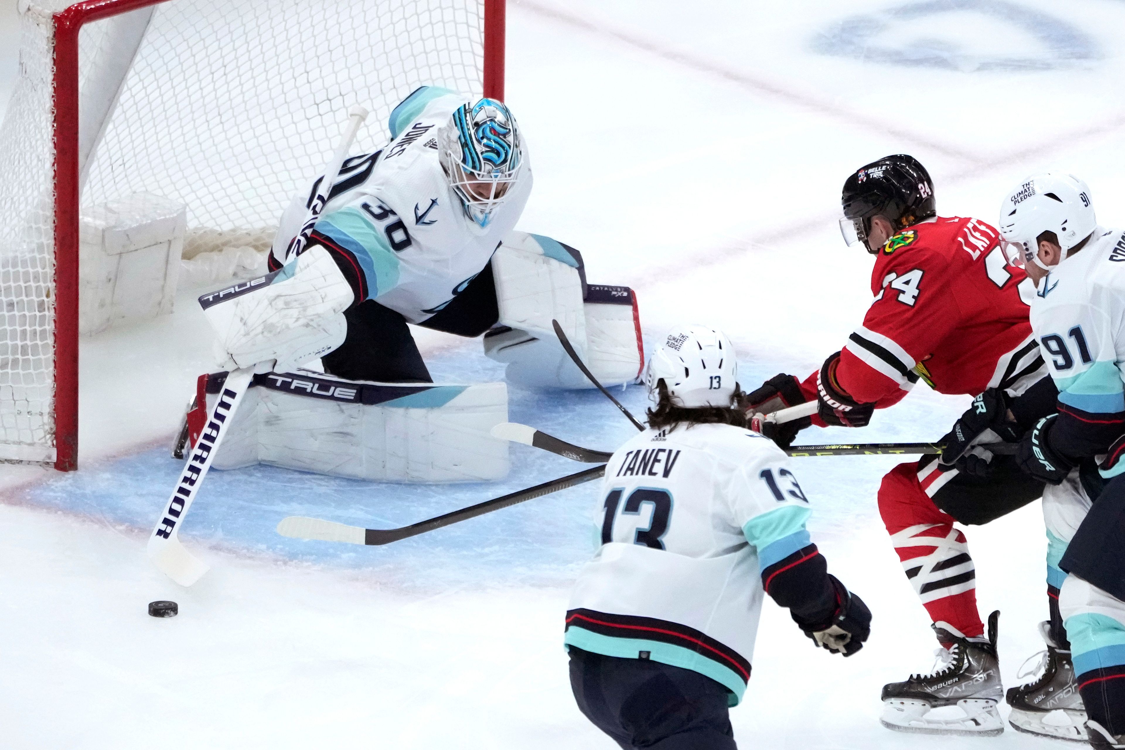 Seattle Kraken goaltender Martin Jones deflects the puck away from Chicago Blackhawks' Sam Lafferty during the first period of an NHL hockey game Saturday, Jan. 14, 2023, in Chicago. (AP Photo/Charles Rex Arbogast)