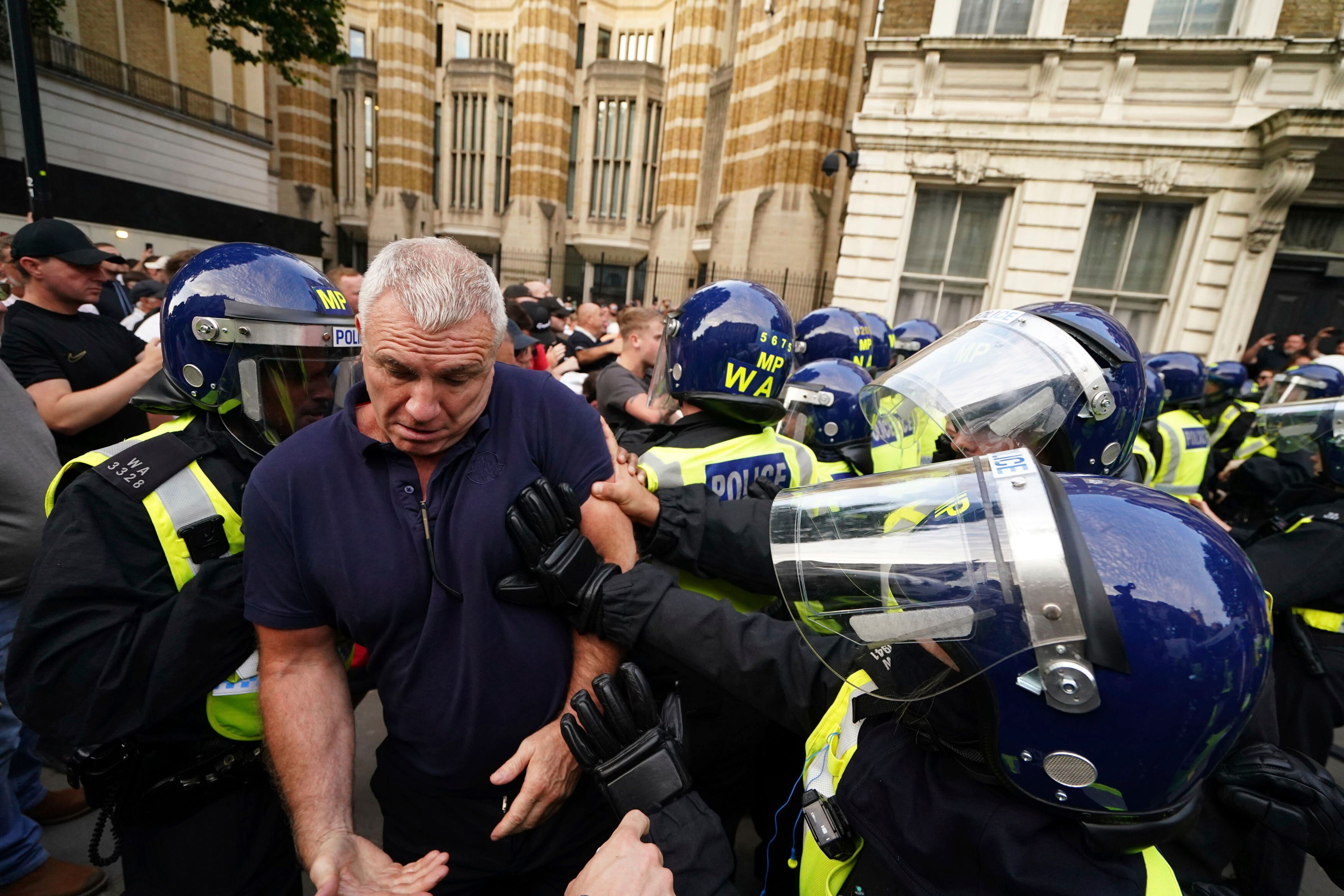 Police officers scuffle with people attending the 'Enough is Enough' protest in Whitehall, London, Wednesday July 31, 2024, following the fatal stabbing of three children at a Taylor Swift-themed holiday club on Monday in Southport. (Jordan Pettitt/PA via AP)