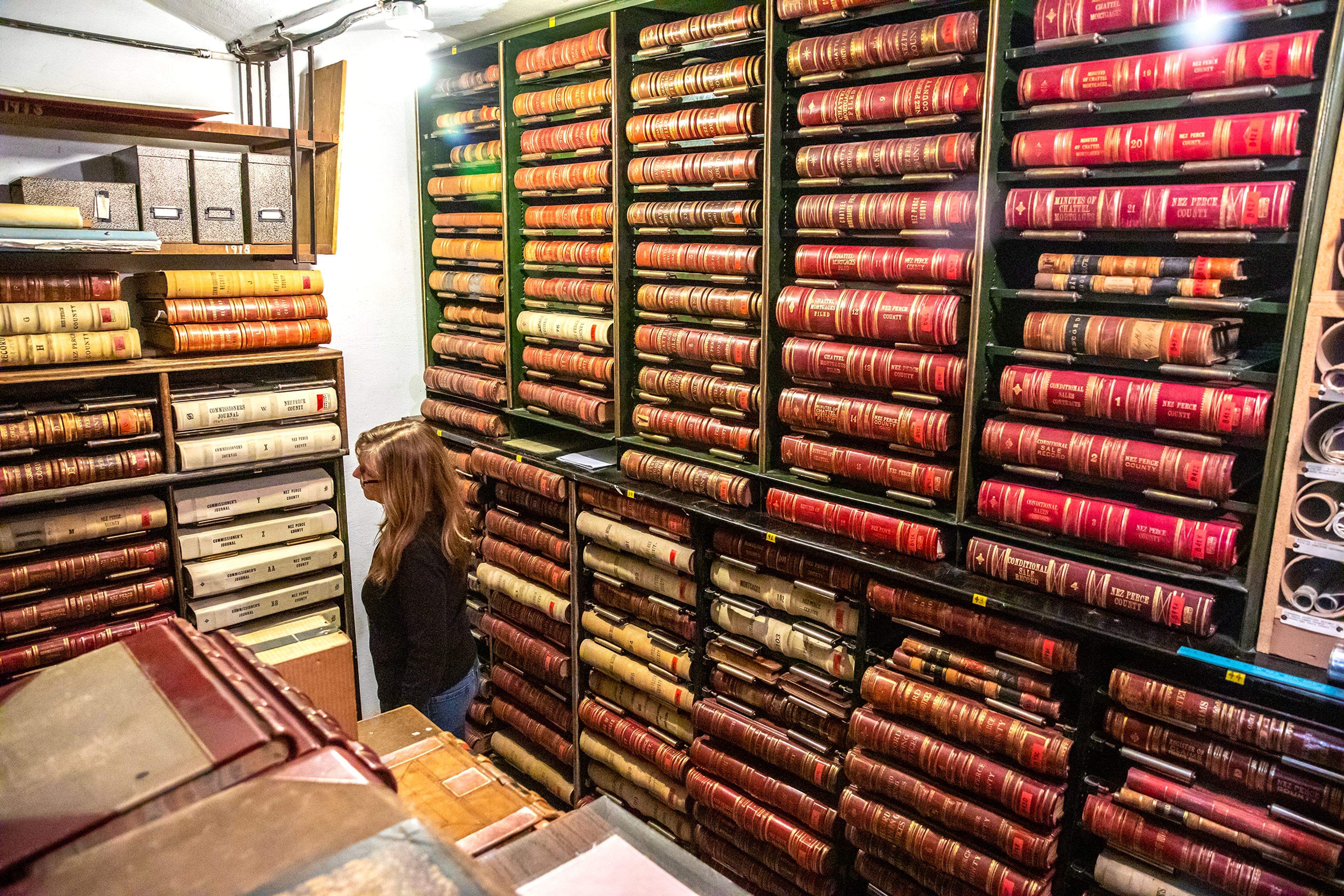 Patty Weeks looks over the shelving of leather-bound books that will be put in the new courthouse Friday at the Nez Perce County Courthouse in Lewiston.