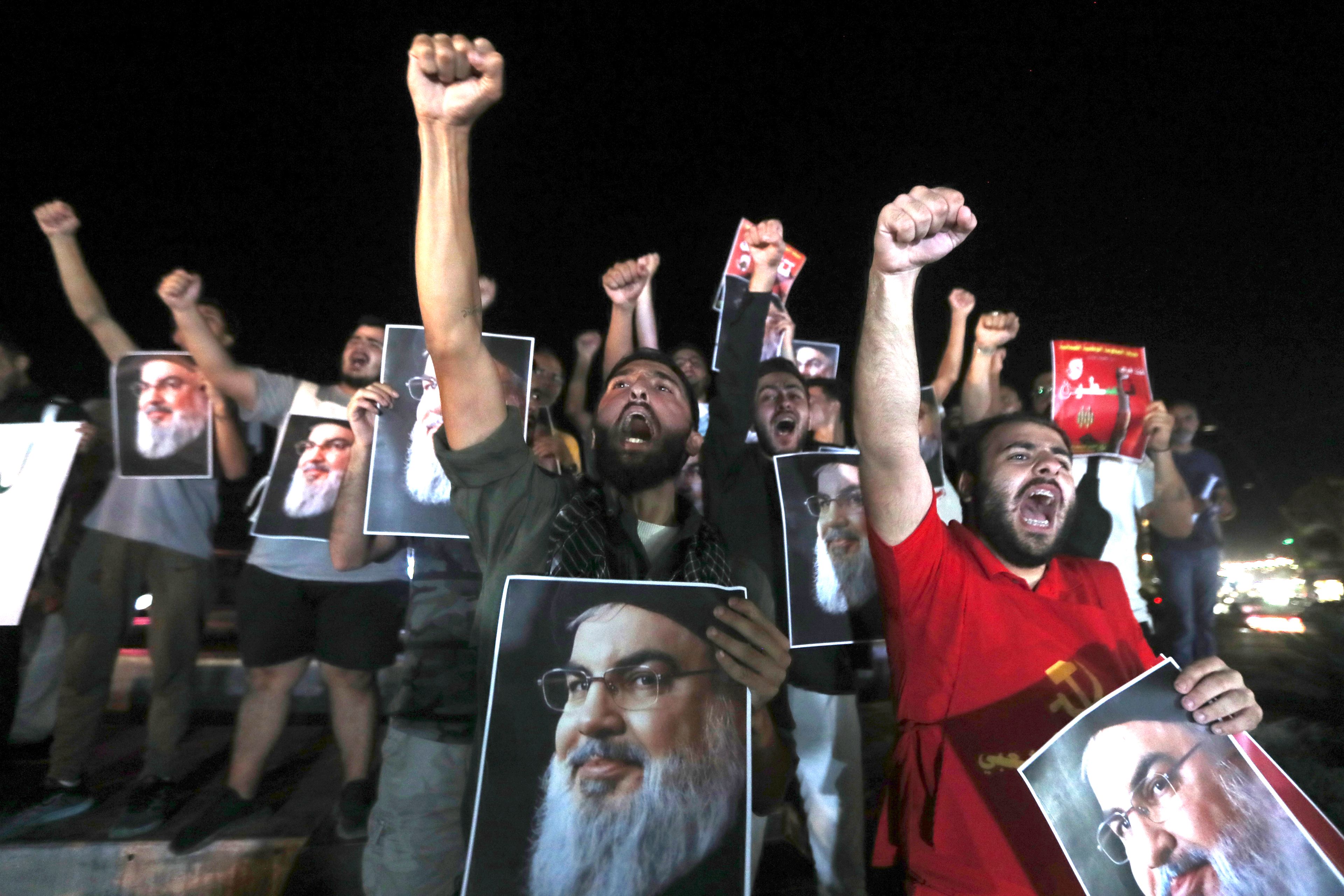 Lebanese and Palestinian men hold portraits of Hezbollah leader Sayyed Hassan Nasrallah, as they shout slogans during a protest in the southern port city of Sidon, Lebanon, Saturday, Sept. 28, 2024. (AP Photo/Mohammed Zaatari)