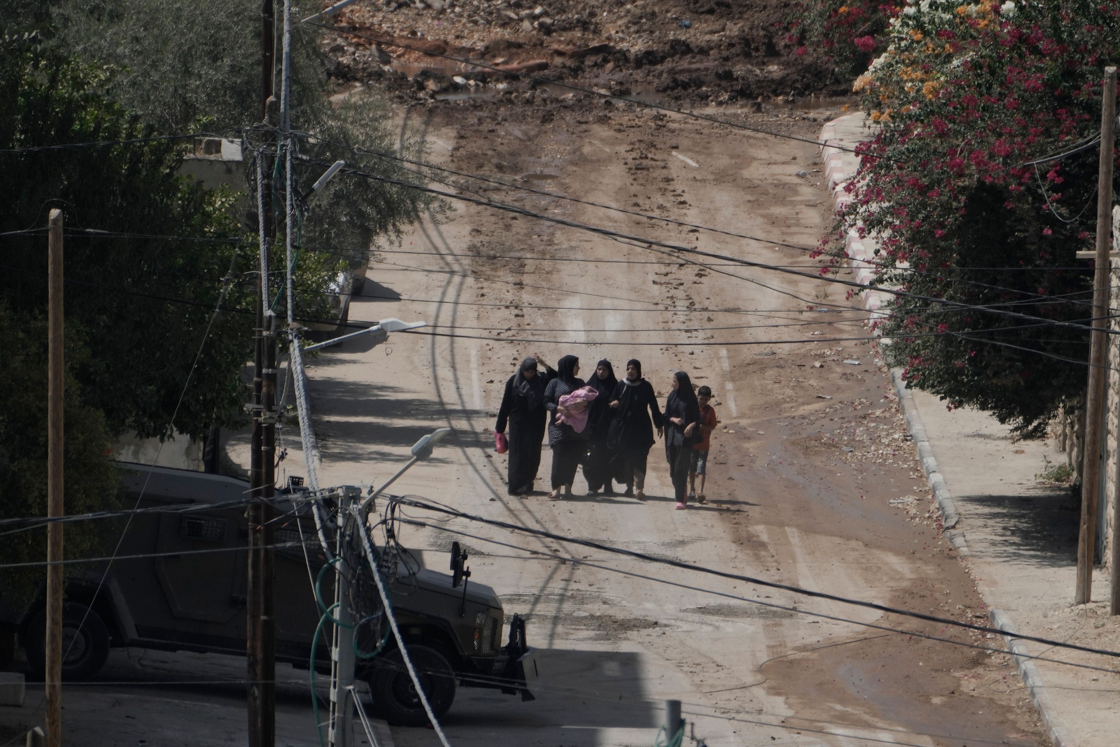 Palestinians walk down a street as they leave the West Bank Jenin refugee camp during an Israeli military operation, Saturday, Aug. 31, 2024. (AP Photo/Majdi Mohammed)