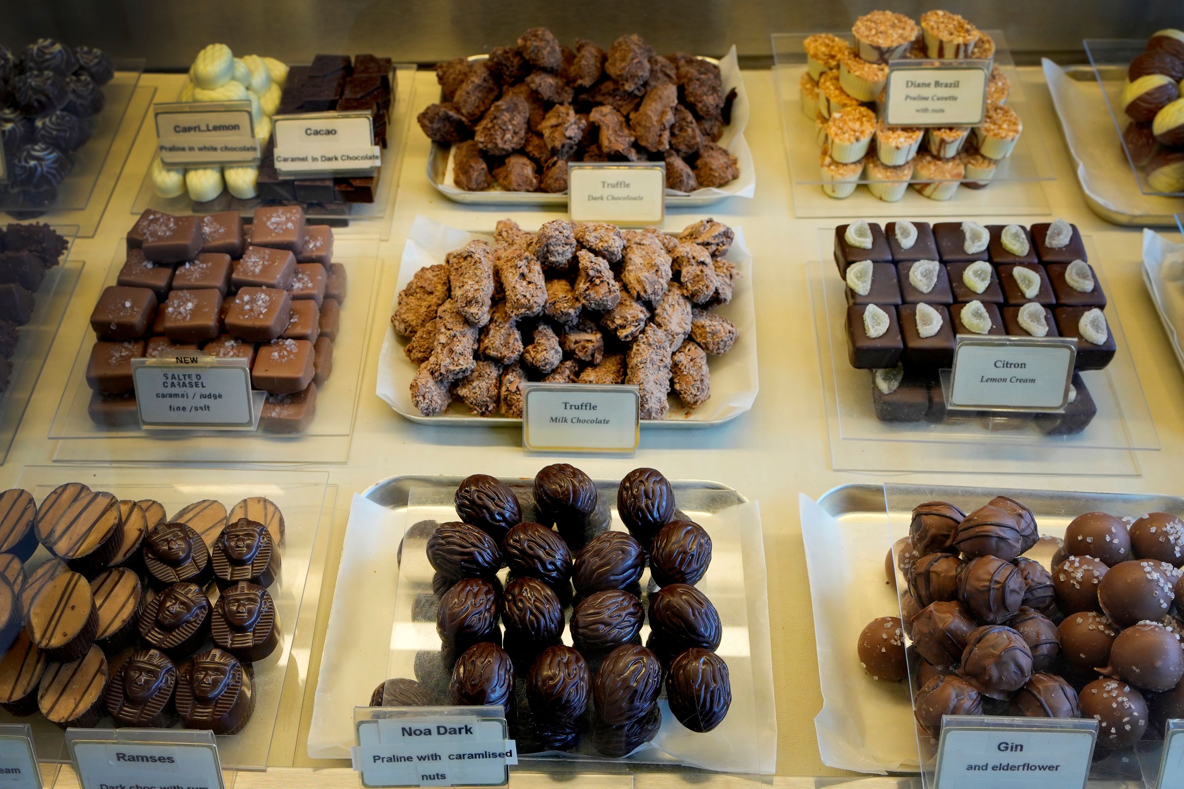 Luxury handmade Belgian Chocolates are seen displayed at Sandrine a chocolate shop owned by Niaz Mardan, in south west London, Thursday, March 21, 2024. Niaz Mardan, is suffering due to high cocoa prices, she's making no profits and fears she will have to close the shop that's been around for 25 years (she's the third owner and took over in 2019). (AP Photo/Kirsty Wigglesworth)