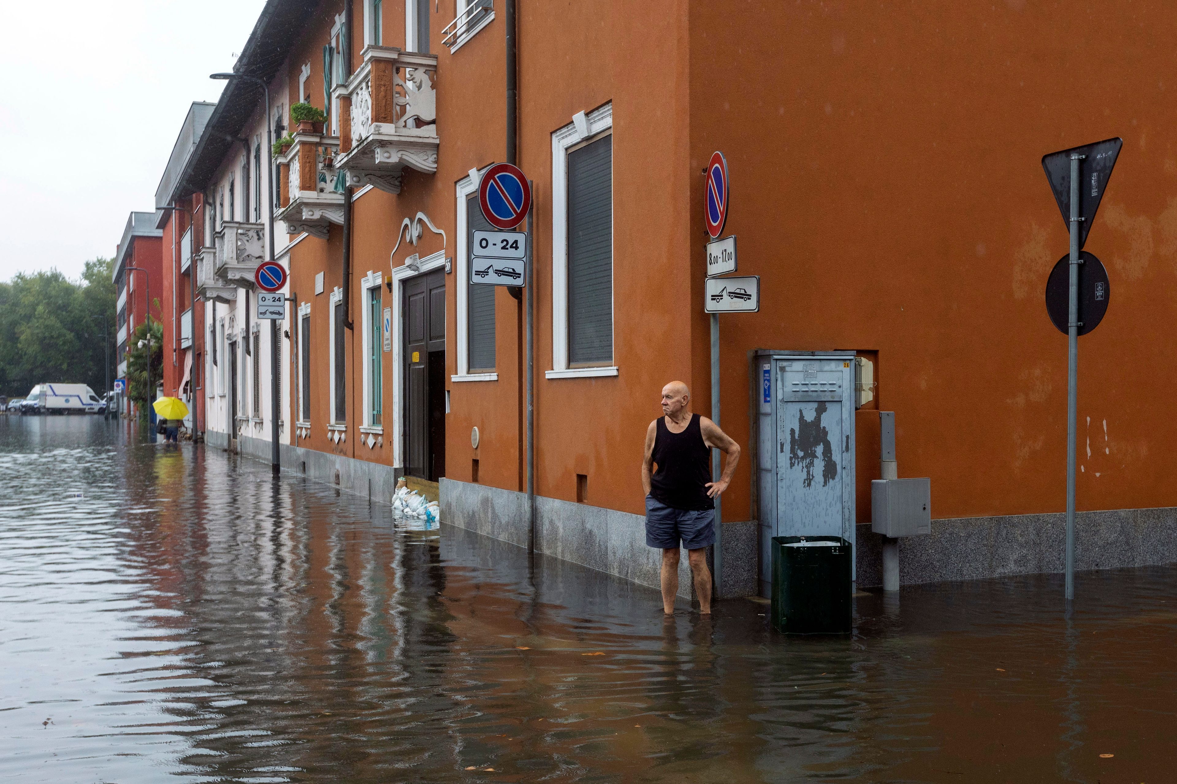 A man stands in floodwater caused by heavy rain in a street in Milan, Italy, Thursday Sept. 5, 2024.