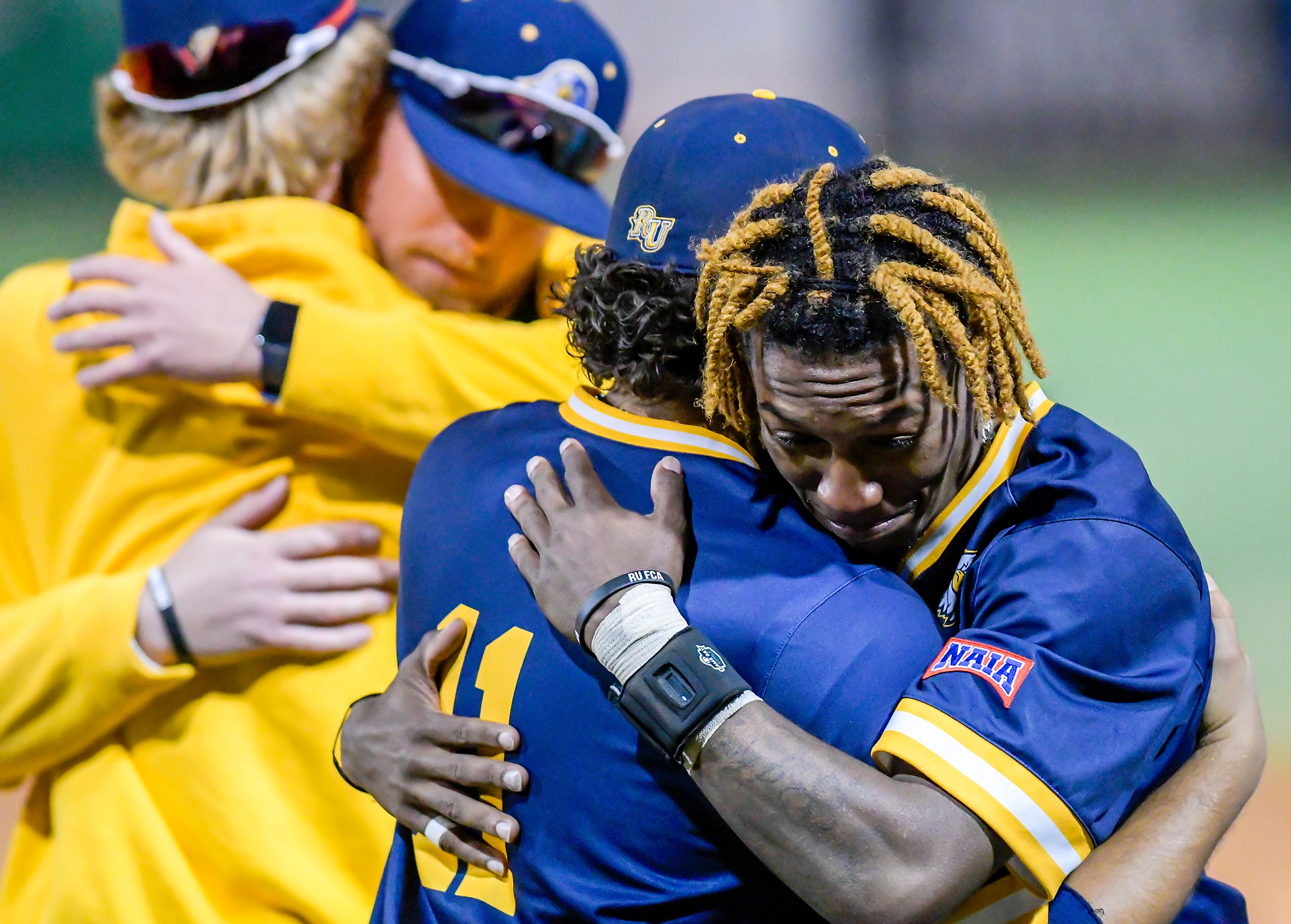 Reinhardt’s Luis Mendoza, left, and Marcerio Allen embrace following their loss to Tennessee Wesleyan in Game 18 of the NAIA World Series at Harris Field Thursday in Lewiston.