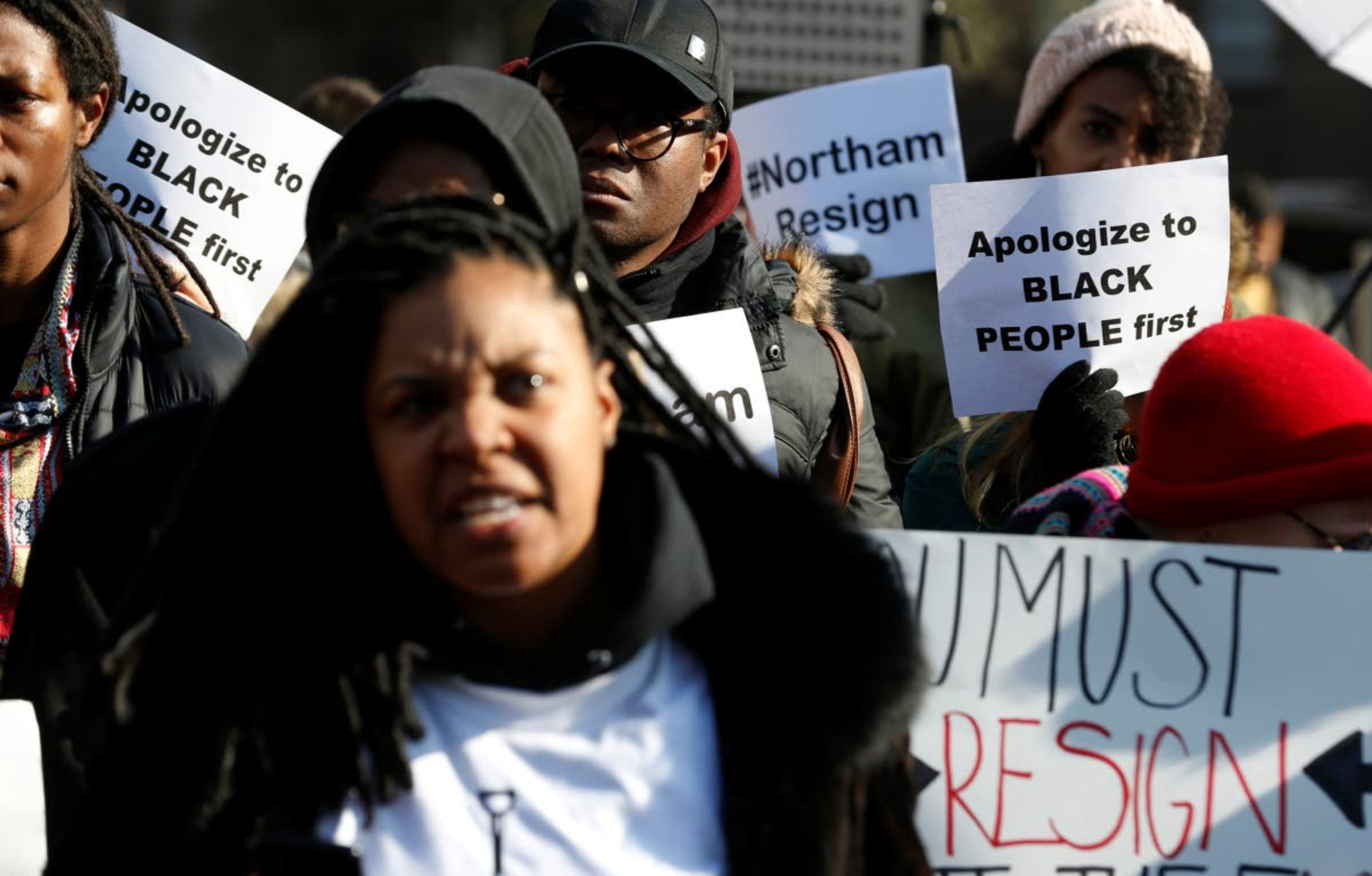 FILE - In this Feb. 2, 2019 file photo, demonstrators hold signs and chant outside the Governors Mansion at the Capitol in Richmond, Va., as they call for the resignation of Virginia Governor Ralph Northam after photo of a person wearing blackface was discovered in his medical school yearbook. The U.S. has spent most of 2019 coming to grips with blackface and racist imagery, but Native Americans say they don't see significant pressure applied to those who perpetuate Native American stereotypes. (AP Photo/Steve Helber, File)