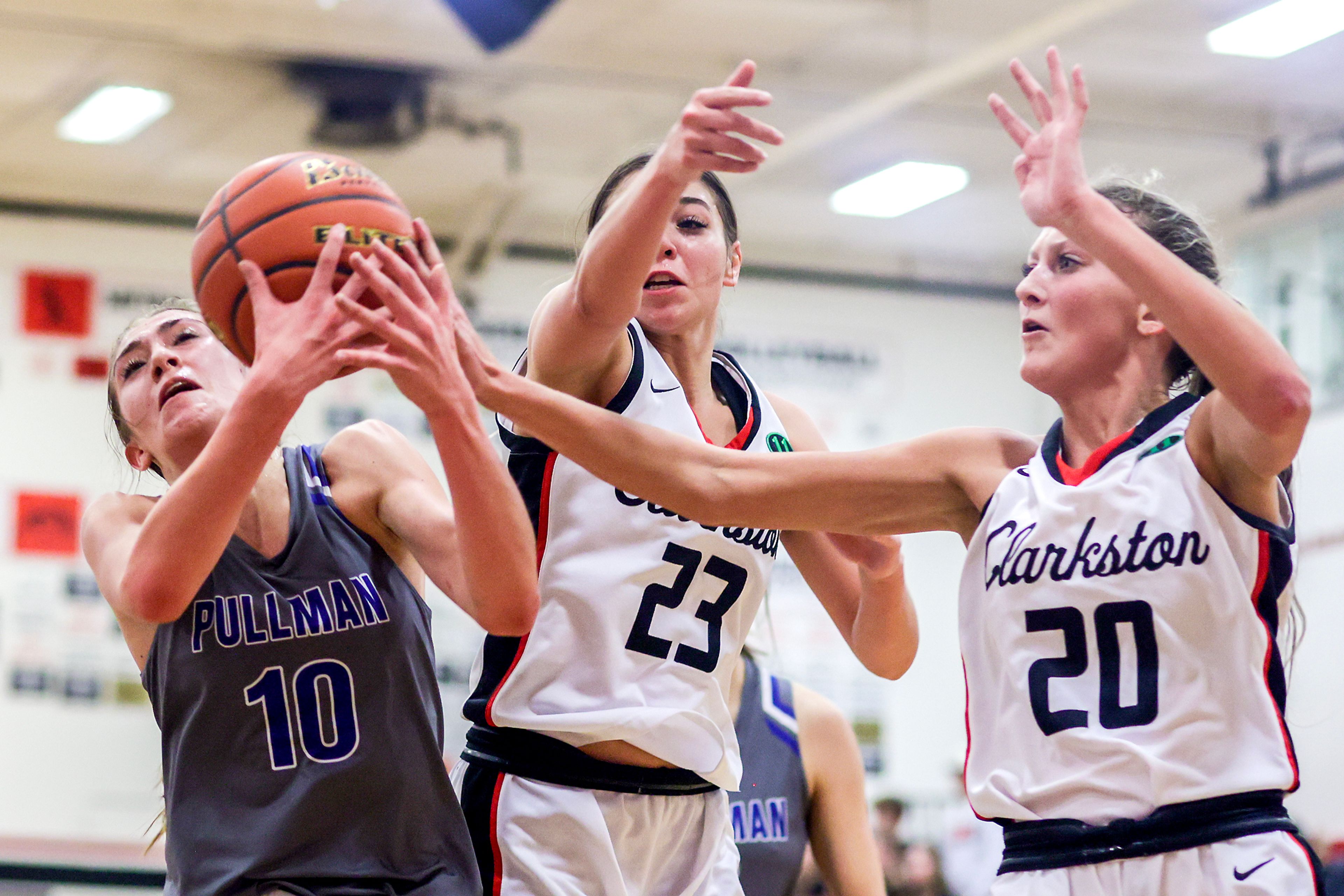 Pullman guard Lacie Sines, left, gets her hands on the ball as Clarkston wing Alahondra Perez, center, and wing Eloise Teasley defend during Tuesday's Class 2A Greater Spokane League girls basketball game.