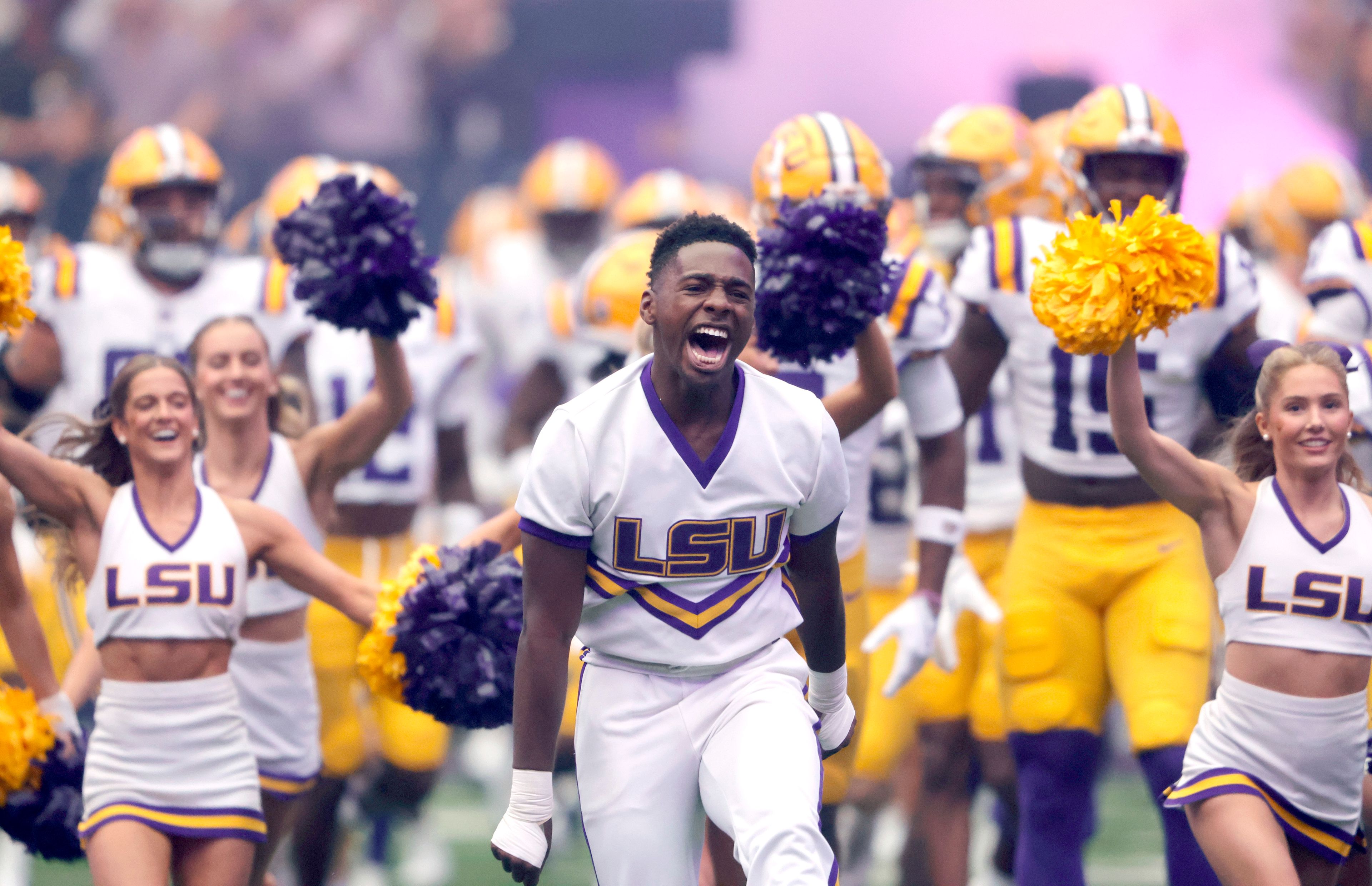 LSU cheerleaders lead players onto the field for an NCAA college football game against Southern California, Sunday, Sept. 1, 2024, in Las Vegas.