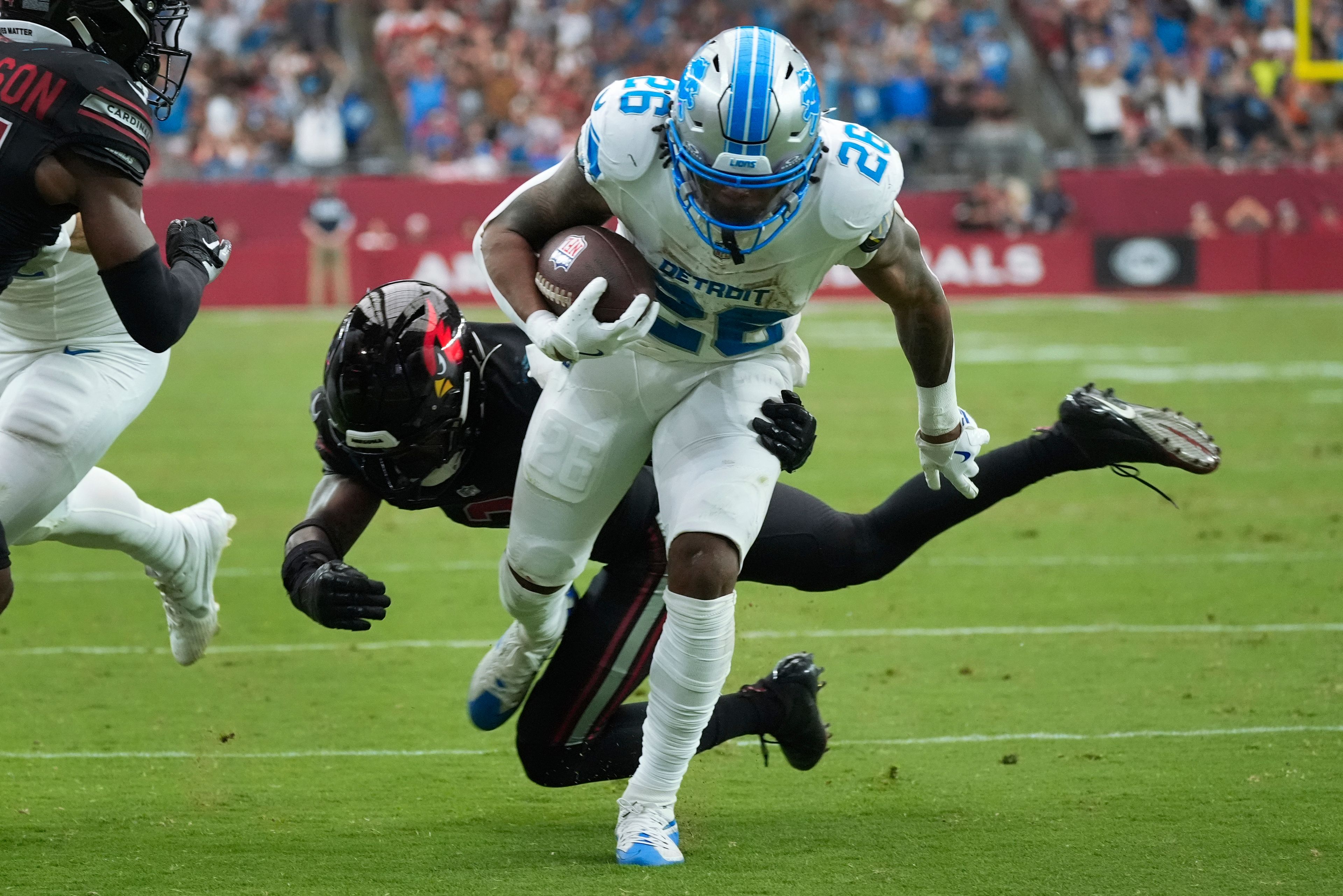 Detroit Lions running back Jahmyr Gibbs (26) scores a touchdown on a run after receiving a lateral from wide receiver Amon-Ra St. Brown during the first half of an NFL football game against the Arizona Cardinals Sunday, Sept. 22, 2024, in Glendale, Ariz. (AP Photo/Ross D. Franklin)