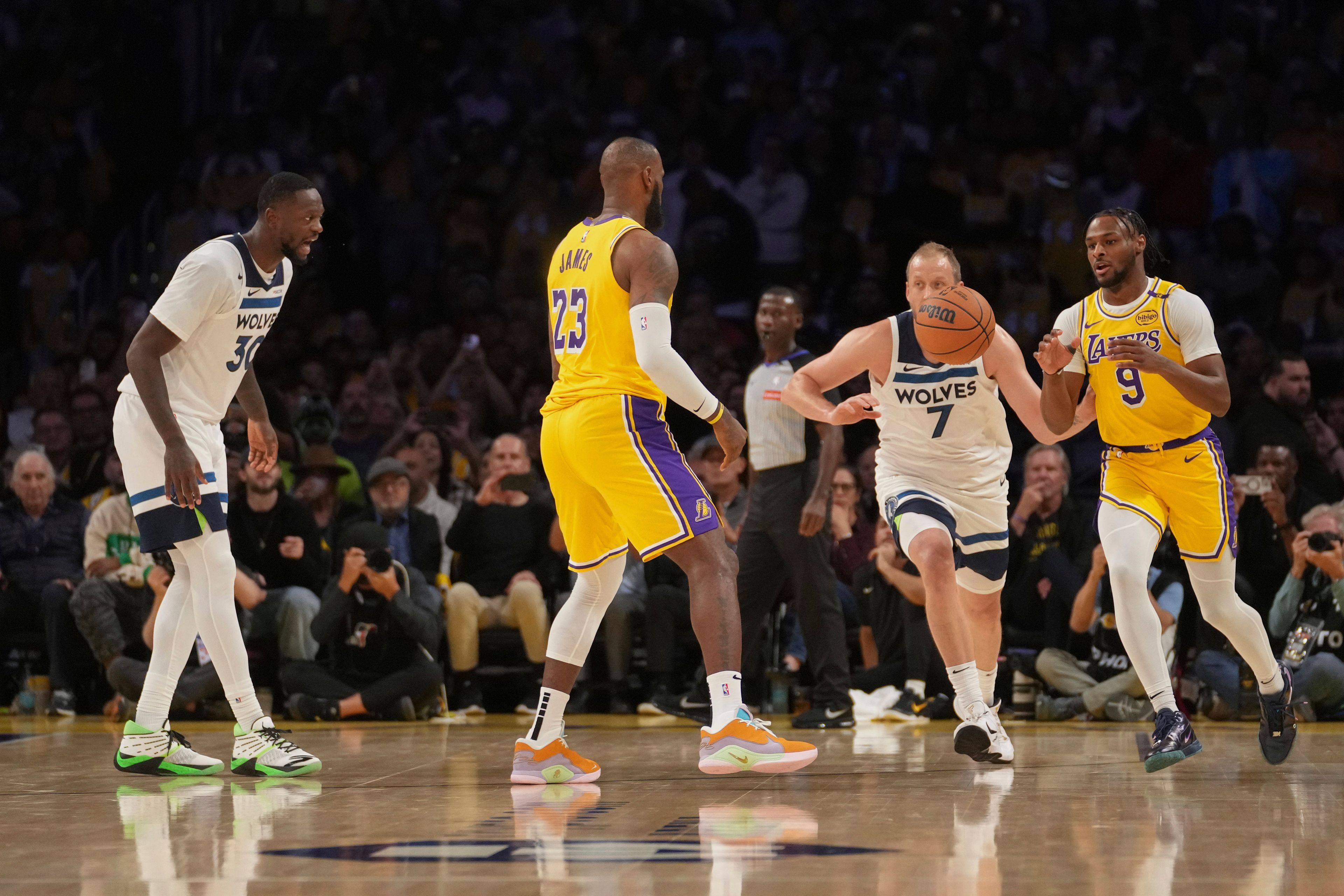 Los Angeles Lakers forward LeBron James (23) passes to guard Bronny James (9) during the first half of an NBA basketball game against the Minnesota Timberwolves, Tuesday, Oct. 22, 2024, in Los Angeles. (AP Photo/Eric Thayer)