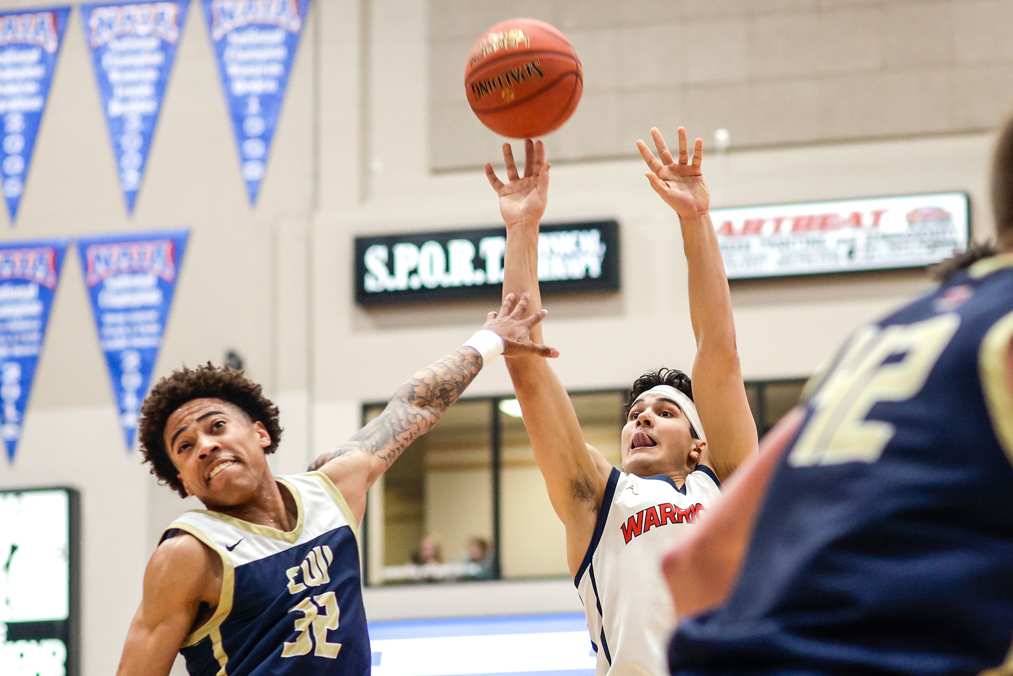 Lewis-Clark State guard Silas Bennion shoots as Eastern Oregon guard Andre Huddleston defends during a Cascade Conference game Friday at Lewis-Clark State College.