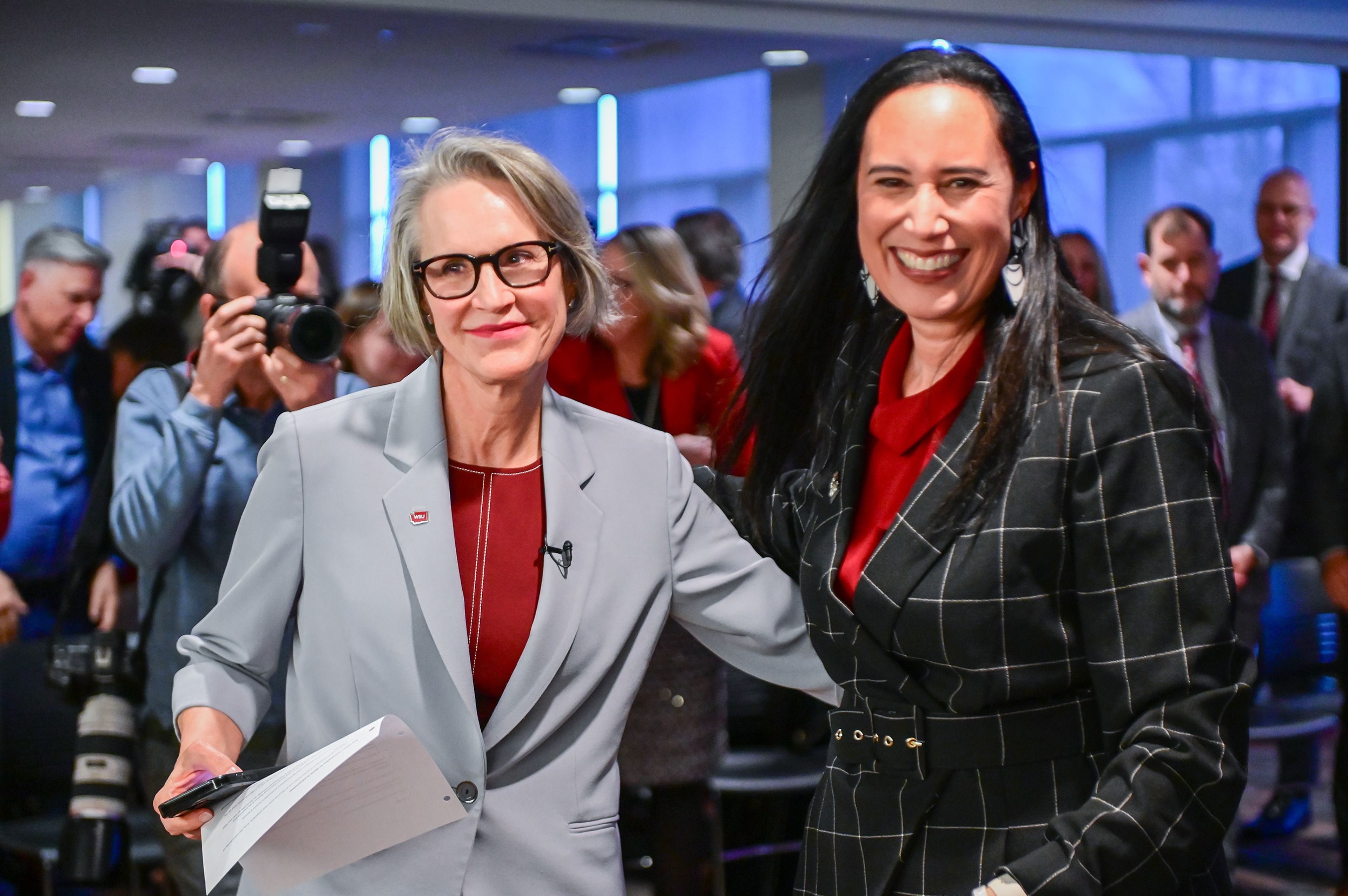 Elizabeth “Betsy” Cantwell, left, reaches an arm around Lisa Keohokalole Schauer, Washington State University Board of Regents Chair, as Cantwell is welcomed after being appointed as Washington State University president Thursday at a regents meeting in Pullman.