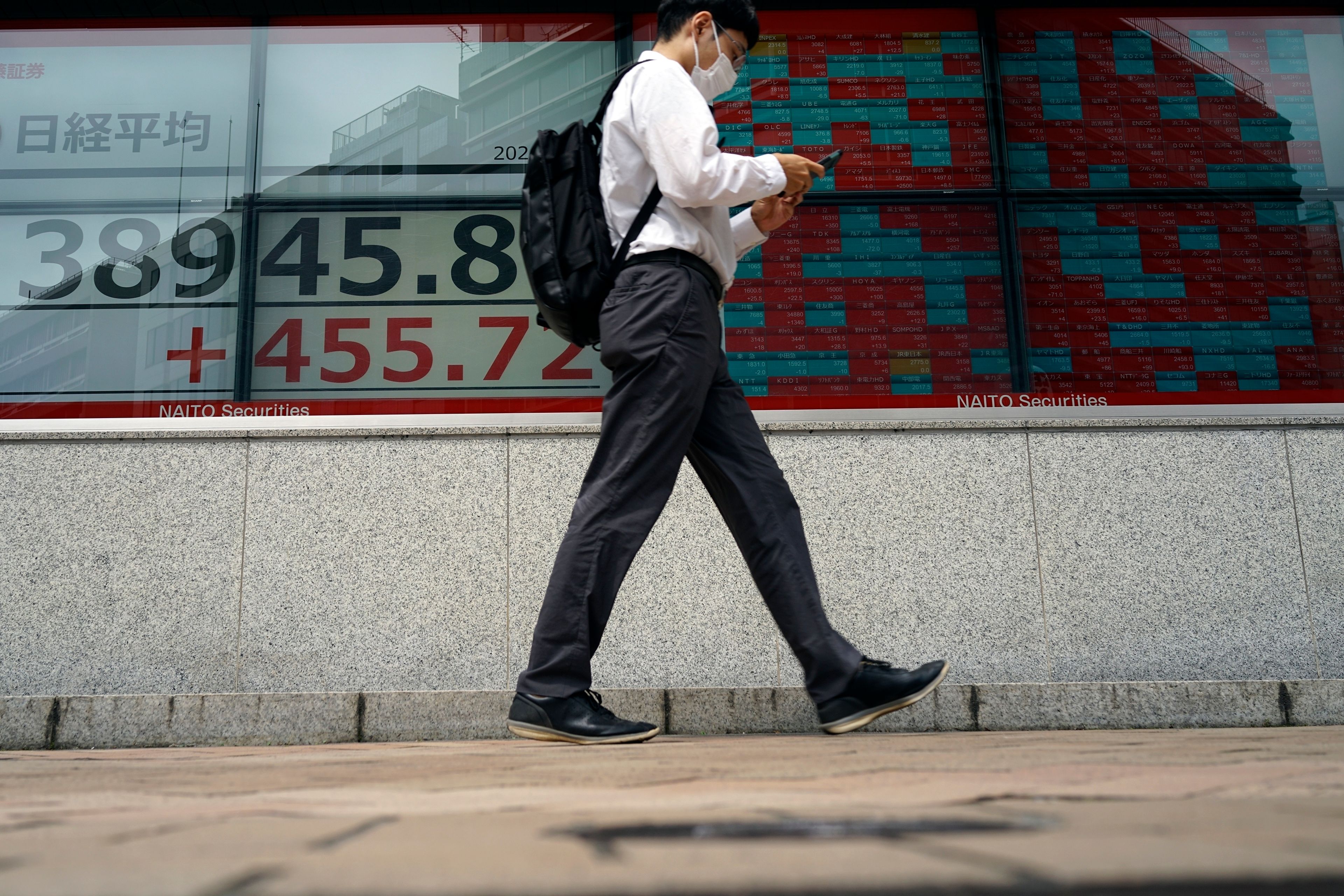 A person walks in front of an electronic stock board showing Japan's Nikkei 225 index at a securities firm Thursday, June 6, 2024, in Tokyo.