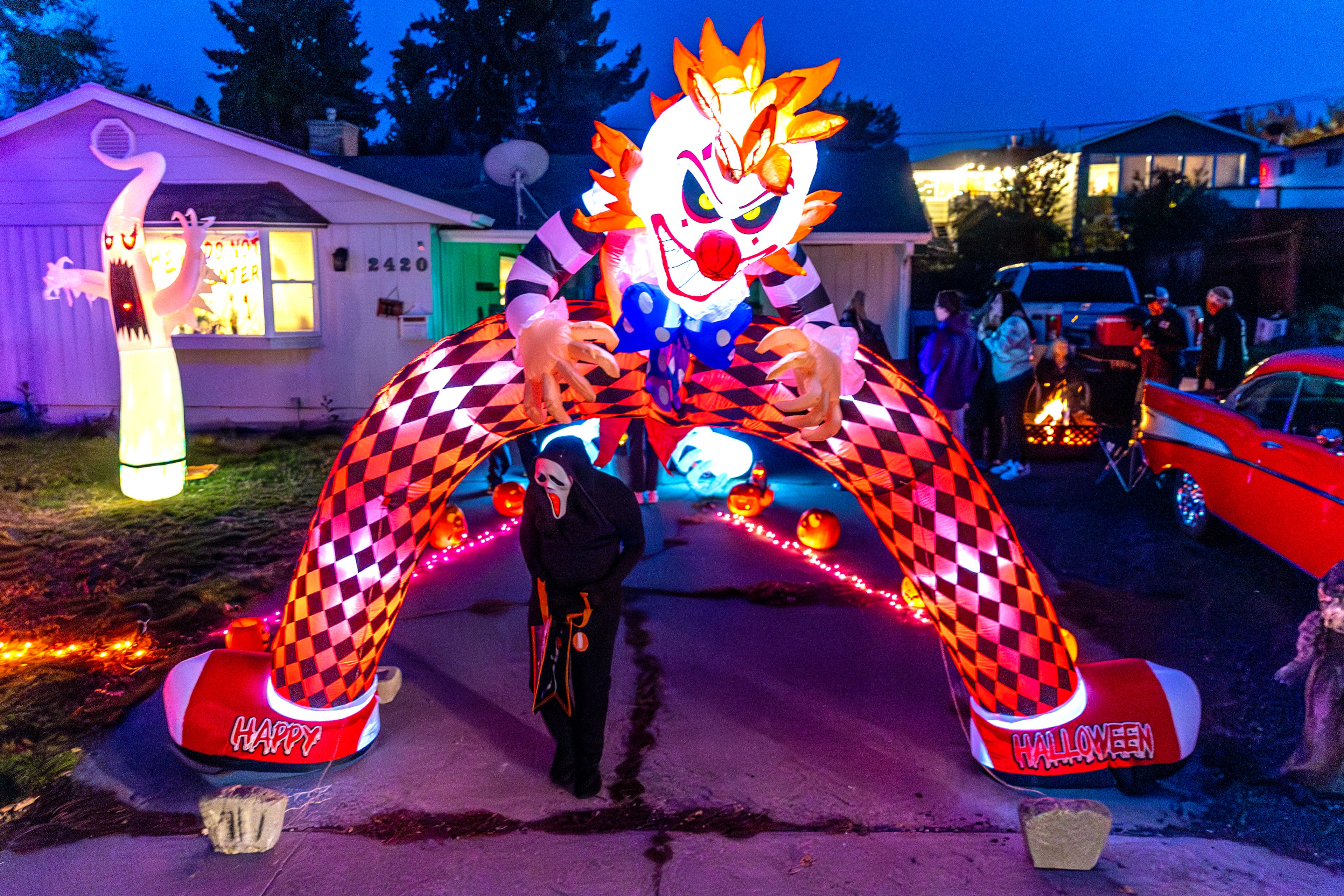 A visitor dressed as Ghostface walks under a terrifying clown archway Thursday in the Sunset Drive neighborhood in Lewiston.