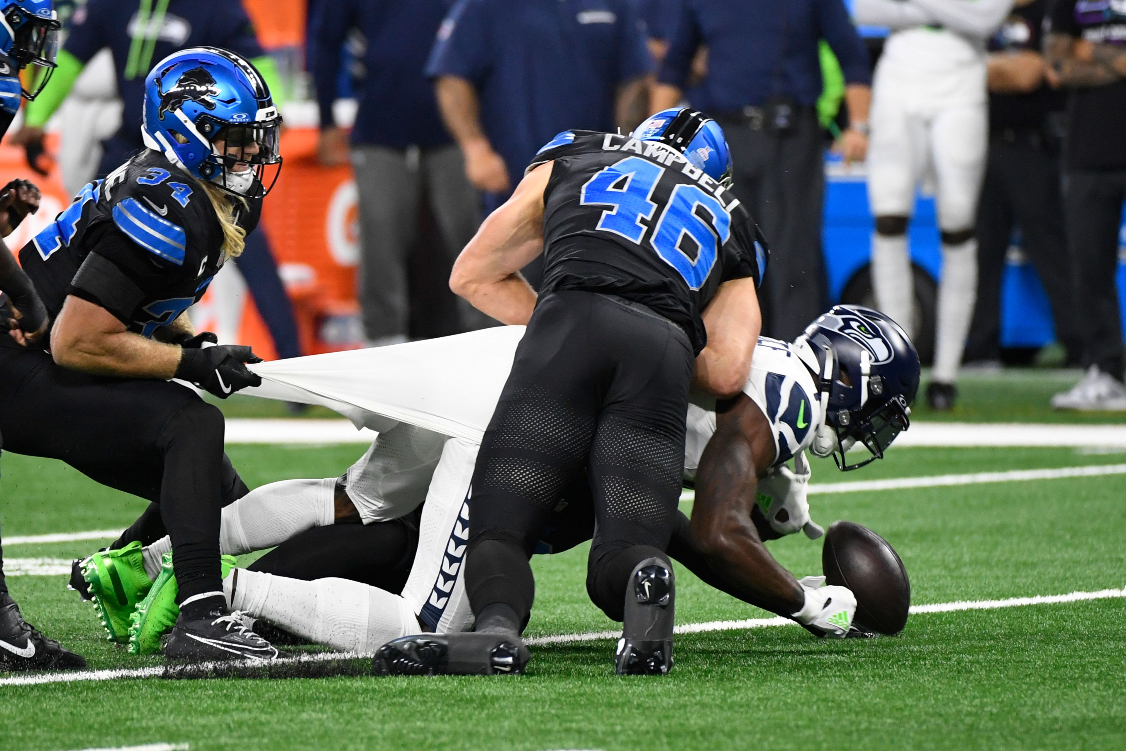 Detroit Lions linebacker Jack Campbell (46) hits Seattle Seahawks wide receiver DK Metcalf (14) and forces a fumble during the first half of an NFL football game, Monday, Sept. 30, 2024, in Detroit. (AP Photo/Jose Juarez)