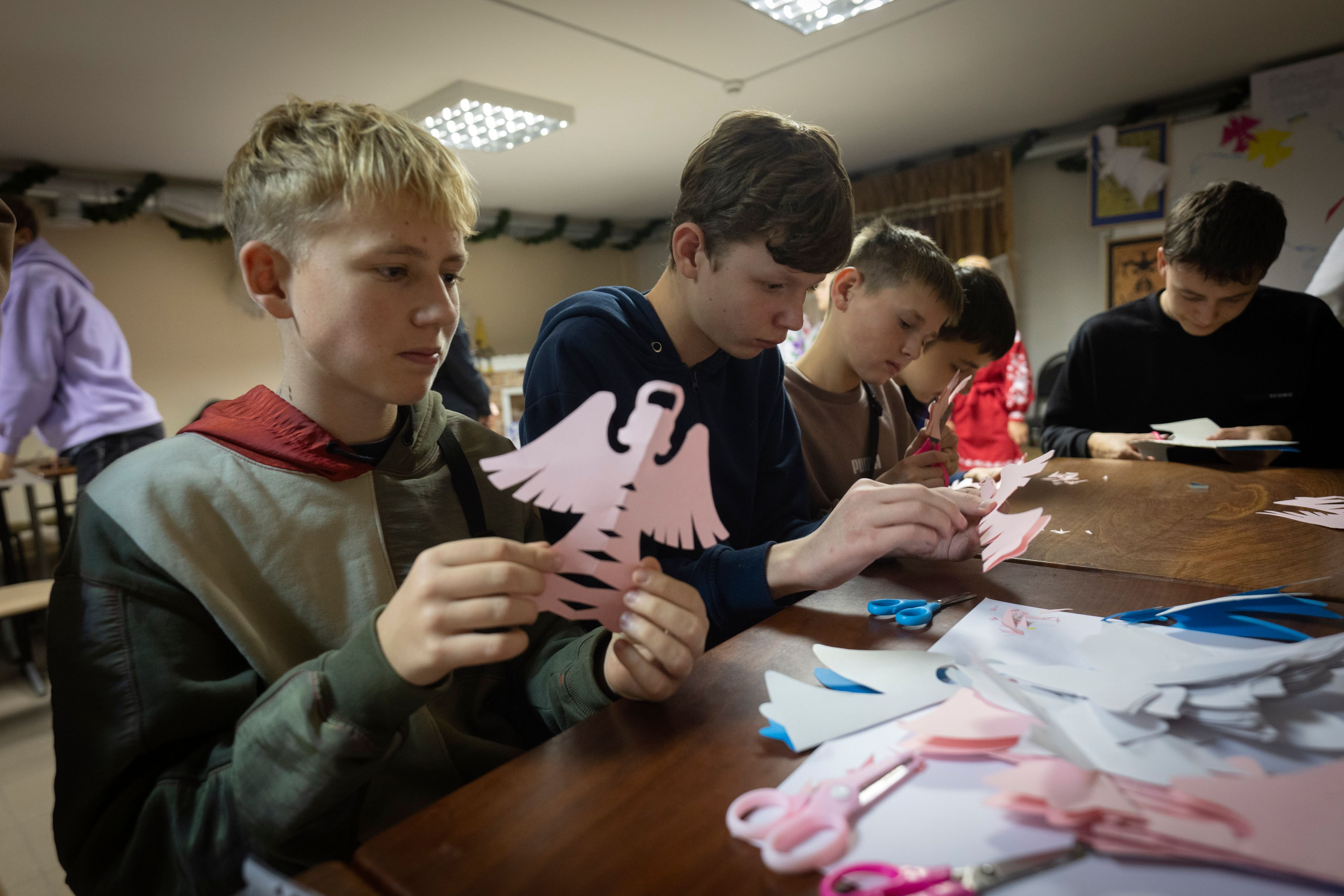 Schoolchildren make decorations for a St. Nicholas Residence and Workshop of Good Deeds in a basement bomb shelter of a military lyceum on World Children's Day in Kyiv, Ukraine, Wednesday, Nov. 20, 2024. (AP Photo/Efrem Lukatsky)