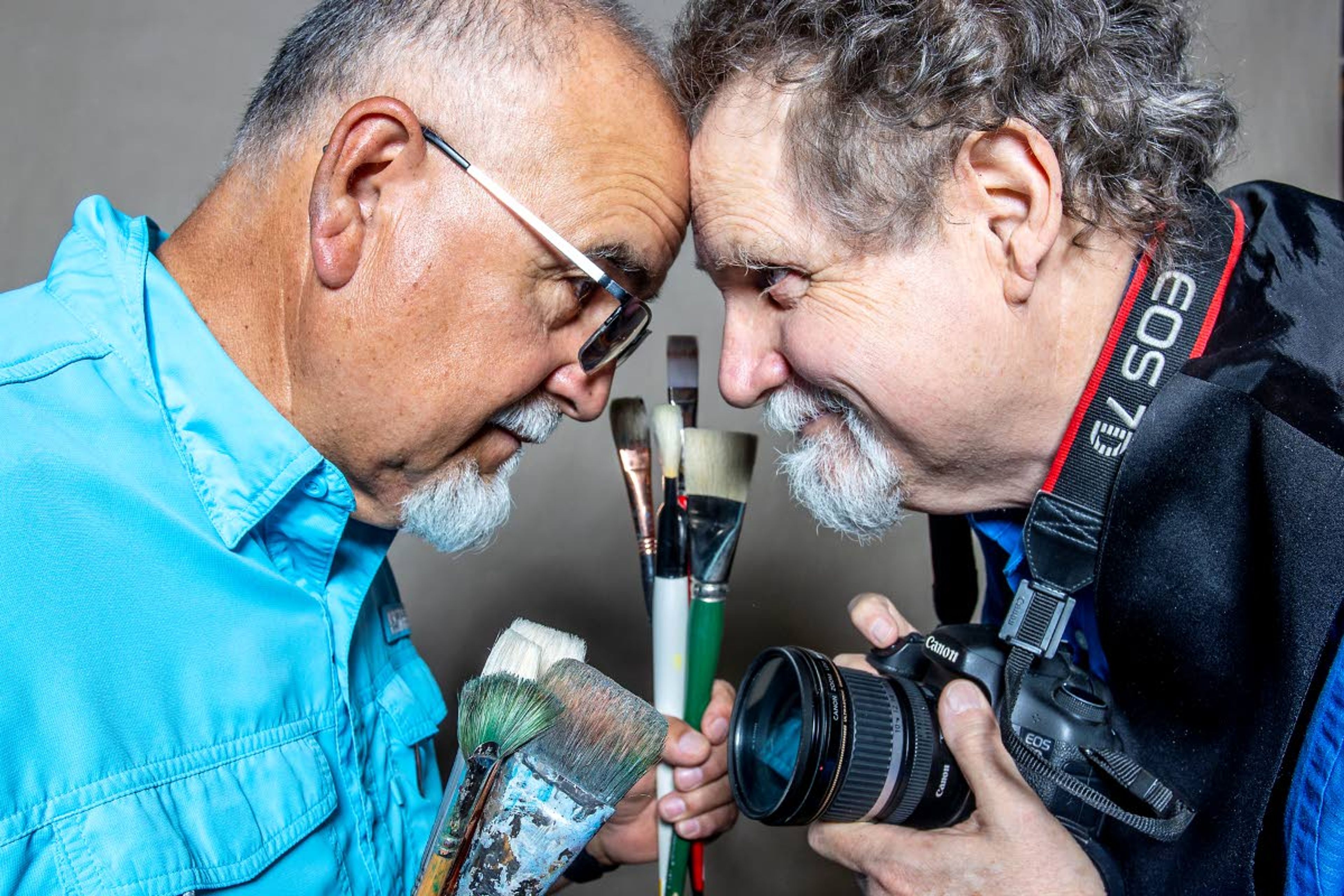 Ray Esparsen and Sean Cassidy go head-to-head for a portrait with tools of their trade in hand Tuesday. The two former Lewis-Clark State College professors will be sharing their work with the public in a show opening Sunday at the Dahmen Barn in Uniontown.