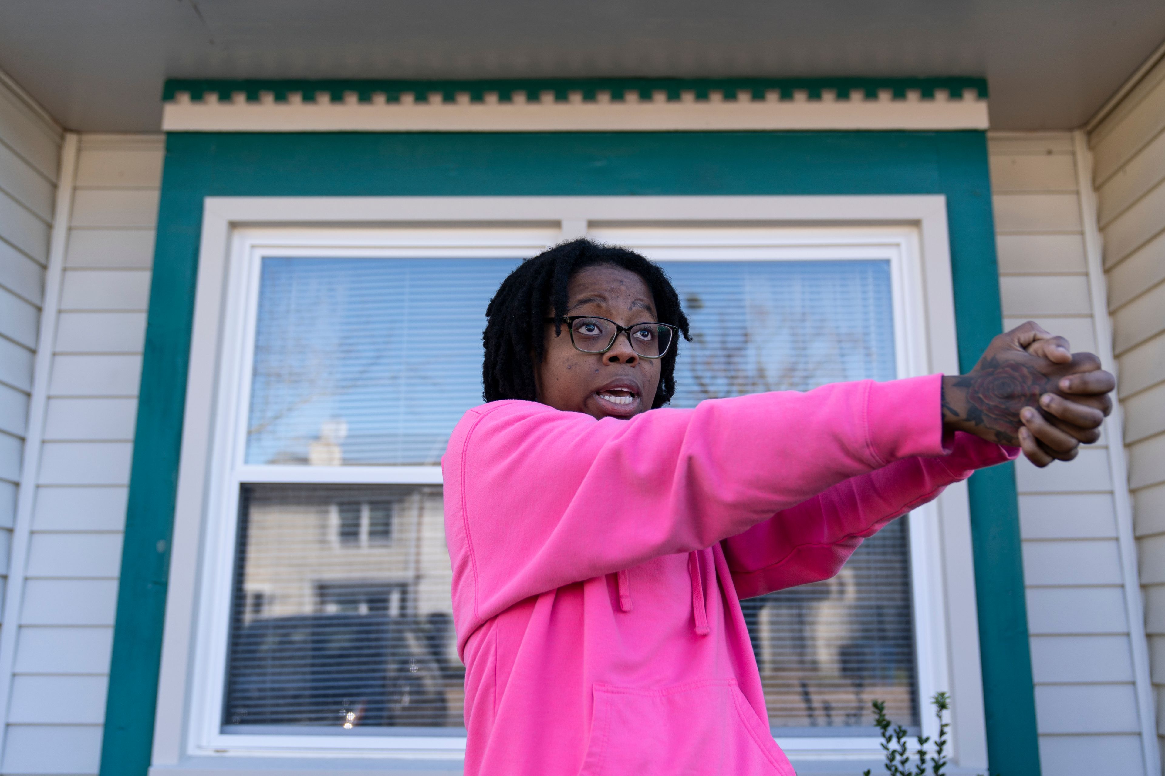 Briana Tyler speaks with The Associated Press and uses her hands like a gun as she demonstrates the gunman shooting indiscriminately, as she talks about witnessing the mass shooting at a Walmart, Wednesday, Nov. 23, 2022, in Chesapeake, Va. Tyler said the overnight stocking team of about 15 or 20 people had just gotten together in the break room to go over the morning plan. As soon as the team was set to start, she said she looked up, and her manager turned around and opened fire on the staff. (AP Photo/Alex Brandon)