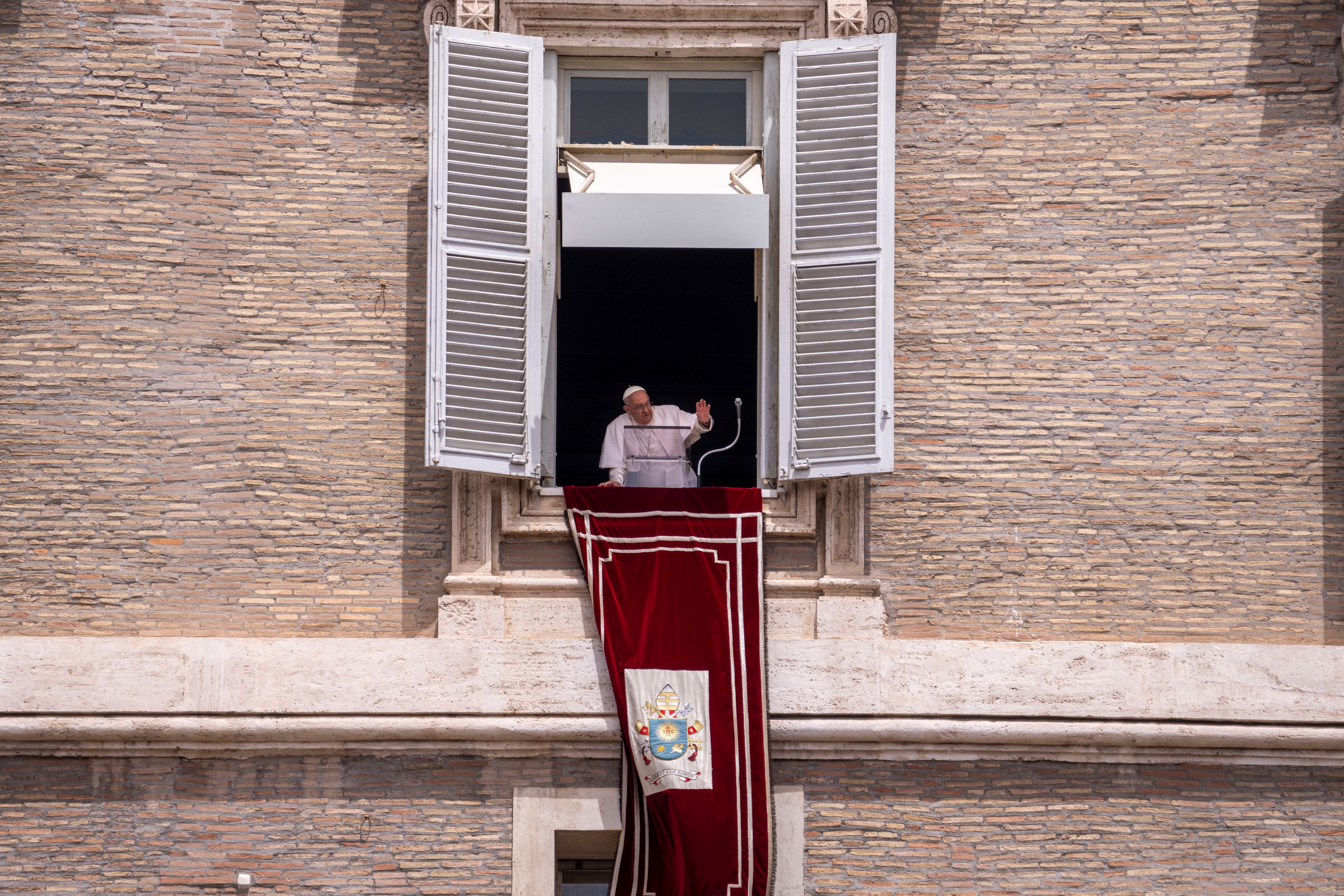 Pope Francis leans from his studiio's window overlooking St. Peter's Square at The Vatican, Sunday, June 9, 2024, where faithful and pilgrims gathered for the traditional Sunday's blessing at the end of the Angelus prayer.