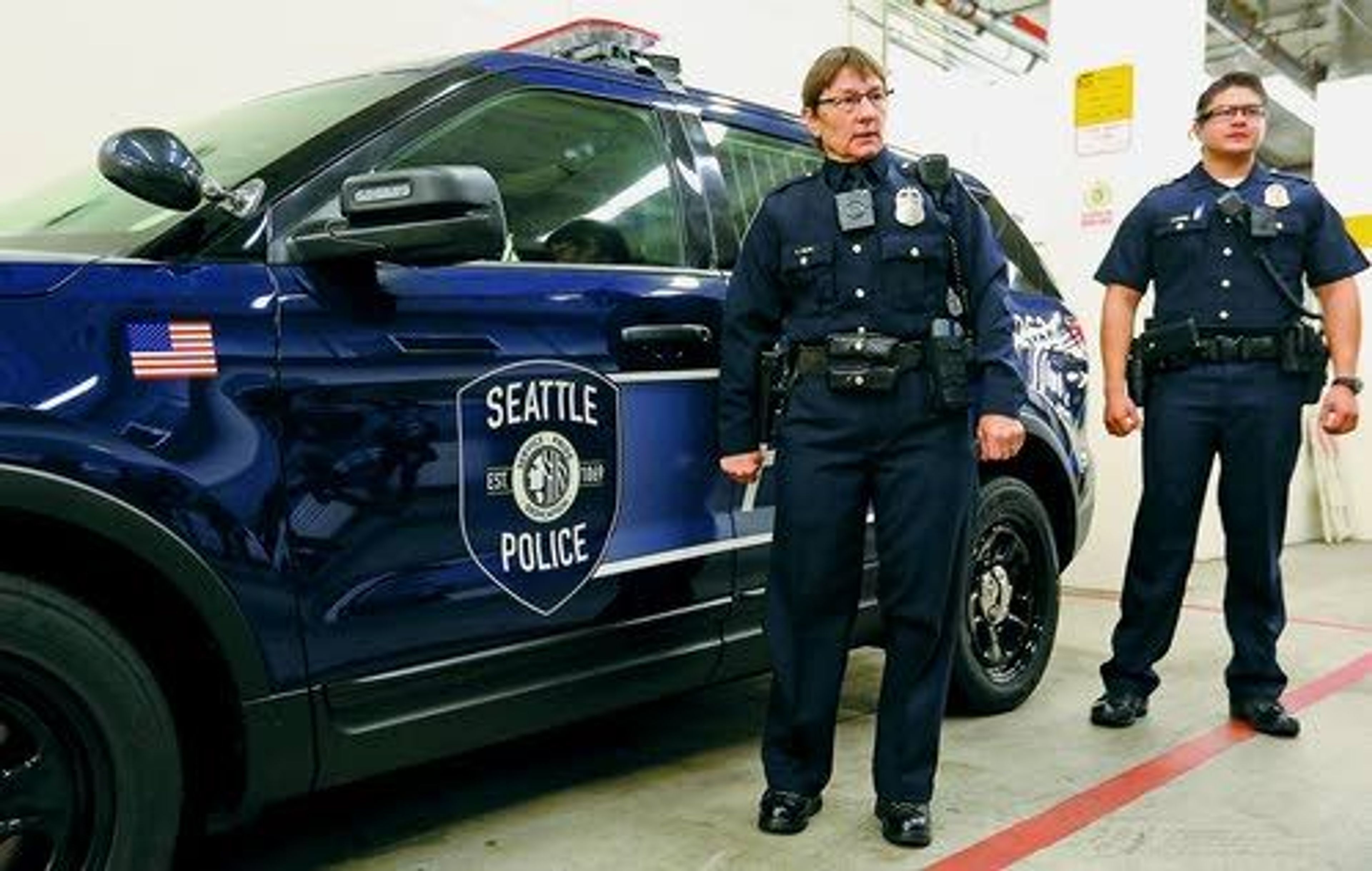 Seattle Police Officers Debra Pelich and Chris Meyers stand next to the department’s new Ford Interceptor SUV during a Thursday news conference in Seattle that also announced new uniforms.