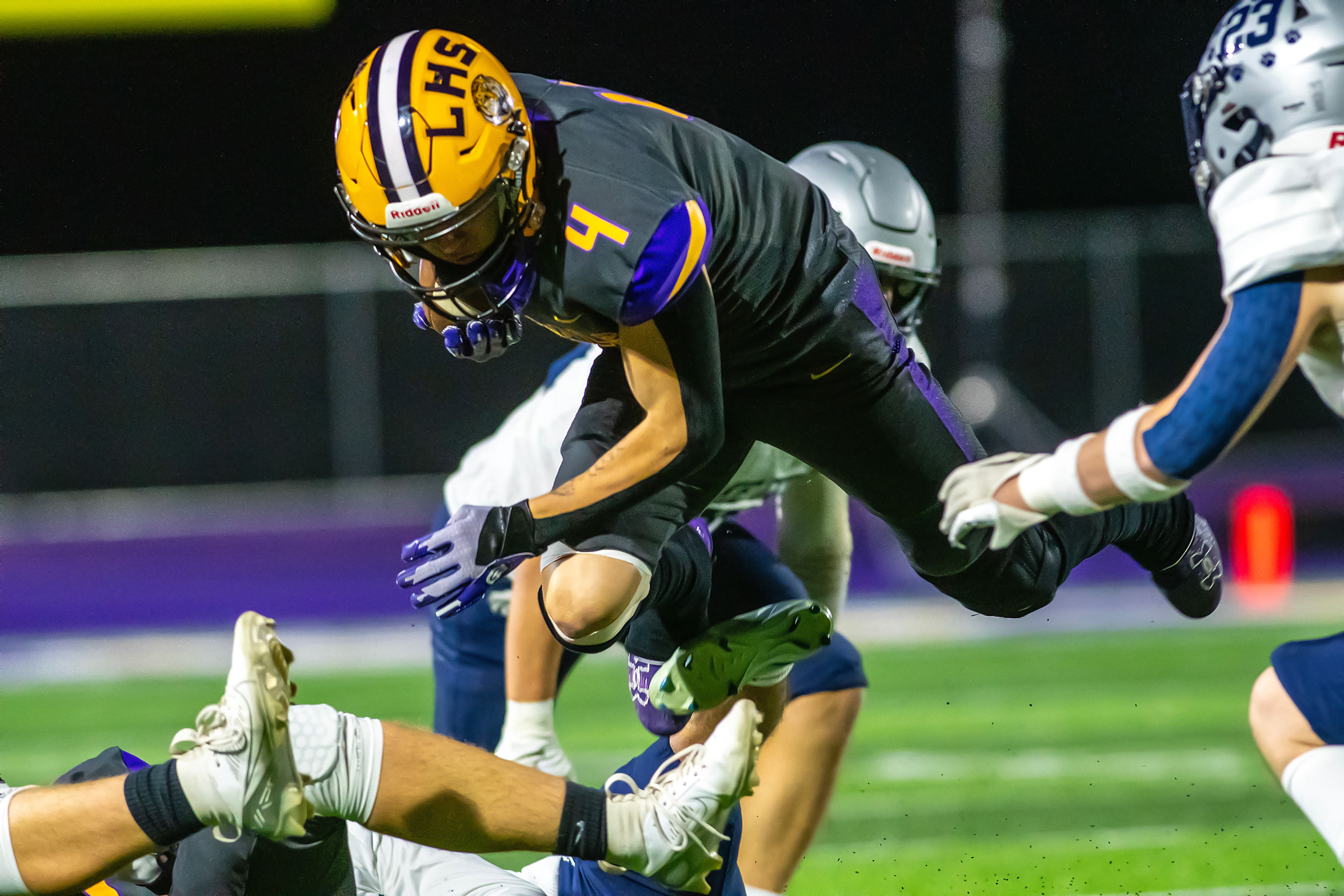 Lewiston running back Noah Carpenter jumps over a Lake City player as he�s brought down during a run in a nonconference game Friday at Lewiston High School.,