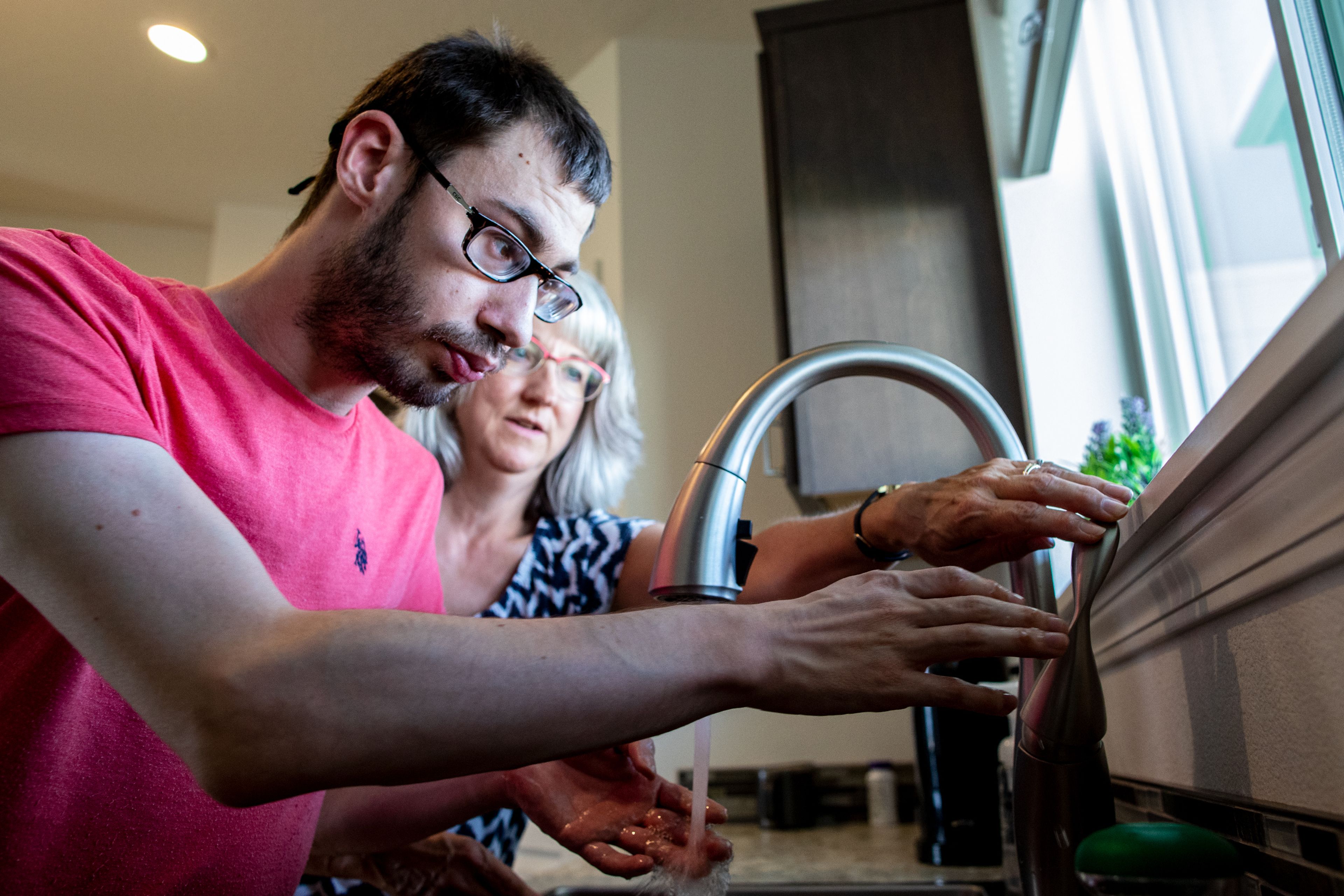 Stephanie Beehner helps her son Kees, 28, wash his hands before dinner at the Beehner’s home in Lewiston on the evening of Sept. 21. “You couldn’t ask for two better parents for a disabled child,” said Jill Grant, Kees Beehner’s 24-Hour supported living house lead, regarding Kees’s parents.