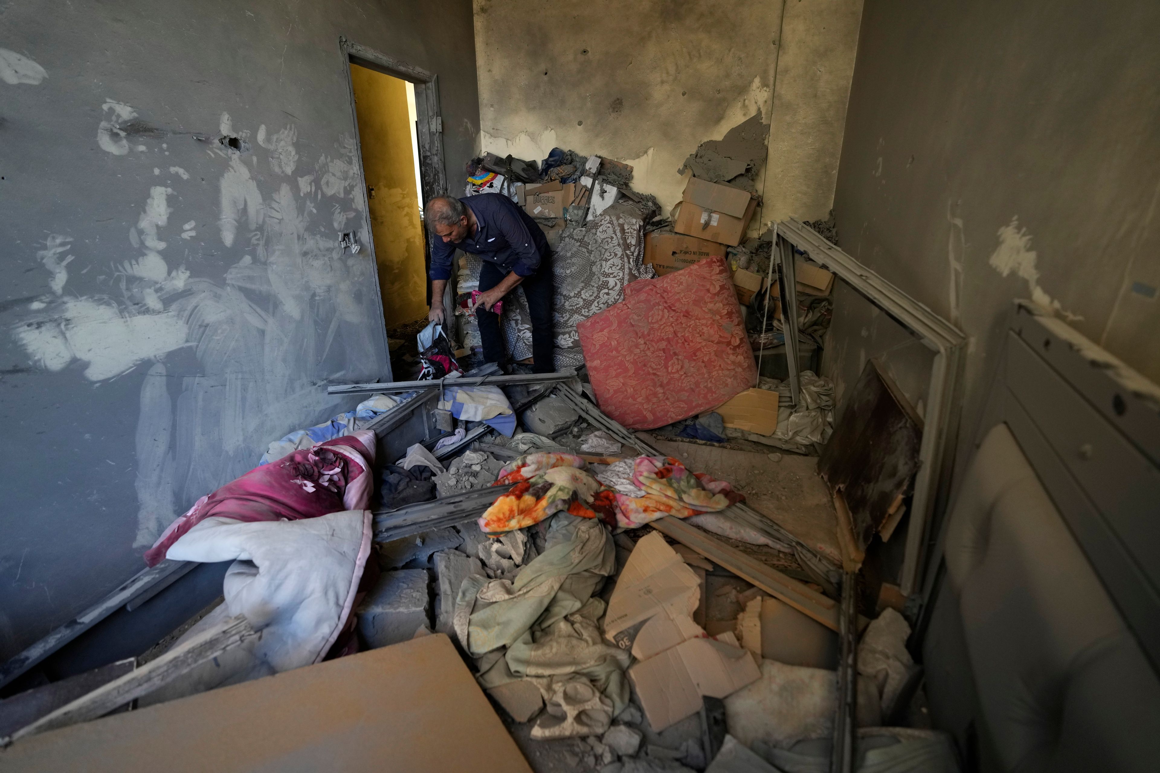 A resident of a building damaged in an Israeli airstrike on Tuesday night, returns to collect his family's belongings in Barja, Lebanon, Wednesday, Nov. 6, 2024. (AP Photo/Hassan Ammar)