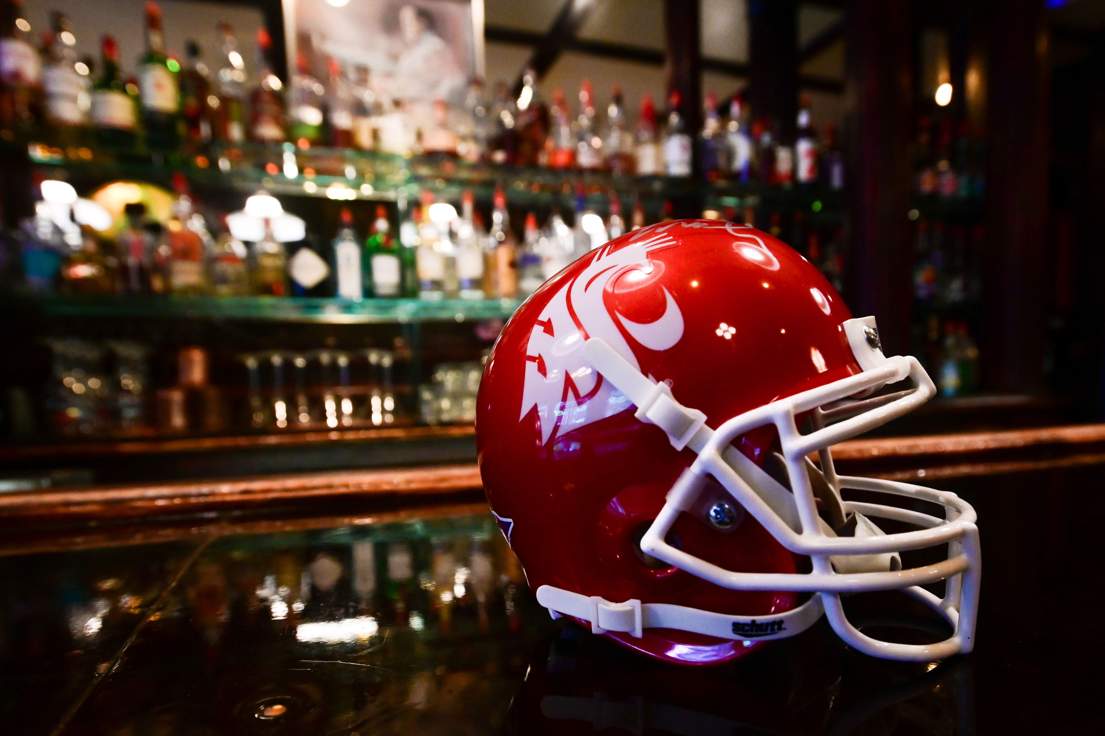 A collector's Washington State Cougars football helmet sits on the bartop at Rico's Public House in downtown Pullman on Thursday. Businesses are anticipating a loss of business as the Cougars face realignment.