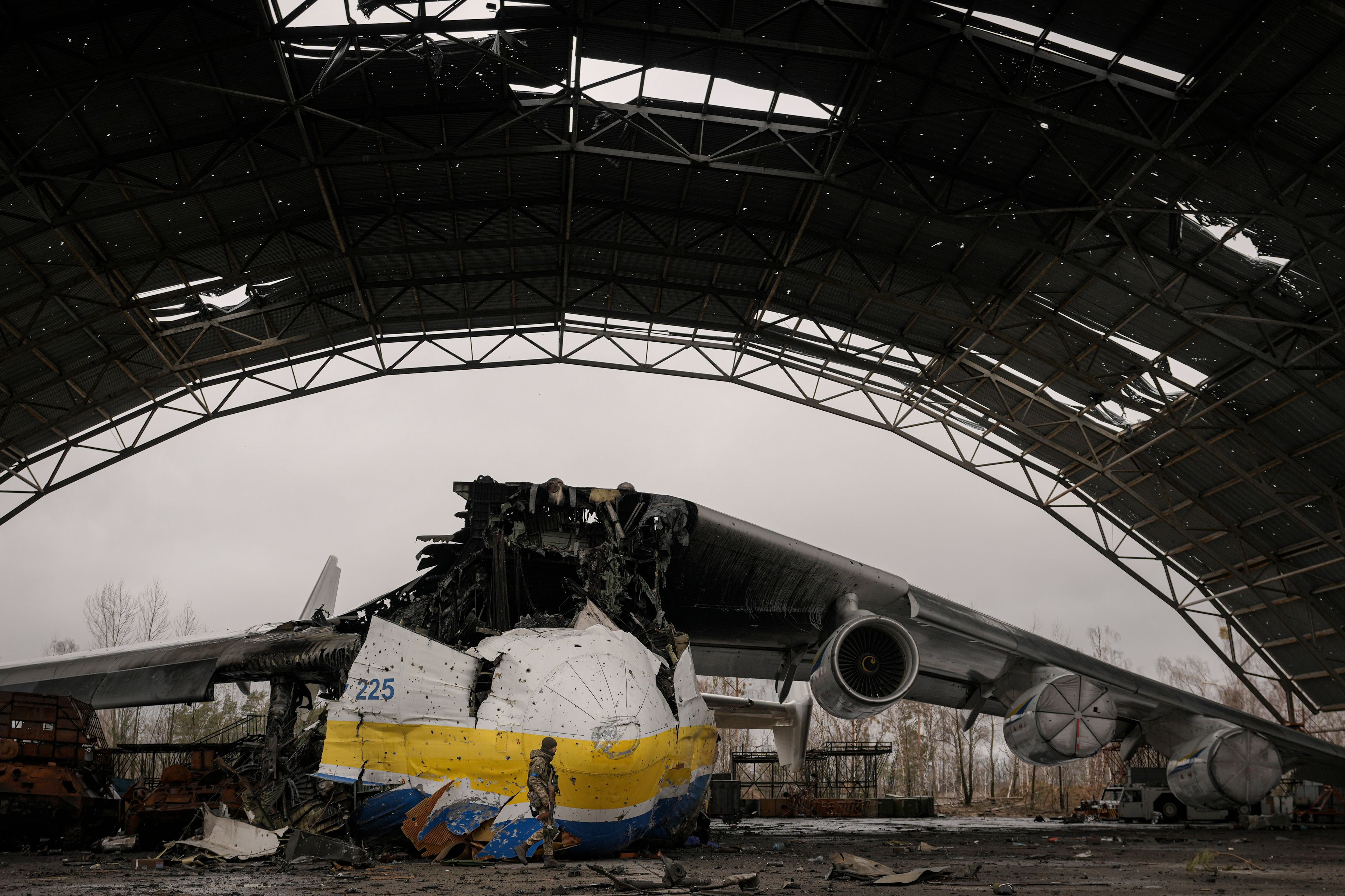 A Ukrainian serviceman walks by an Antonov An-225 Mriya aircraft destroyed during fighting between Russian and Ukrainian forces on the Antonov airport in Hostomel, Ukraine, Saturday, April 2, 2022. At the entrance to Antonov Airport in Hostomel Ukrainian troops manned their positions, a sign they are in full control of the runway that Russia tried to storm in the first days of the war. (AP Photo/Vadim Ghirda)