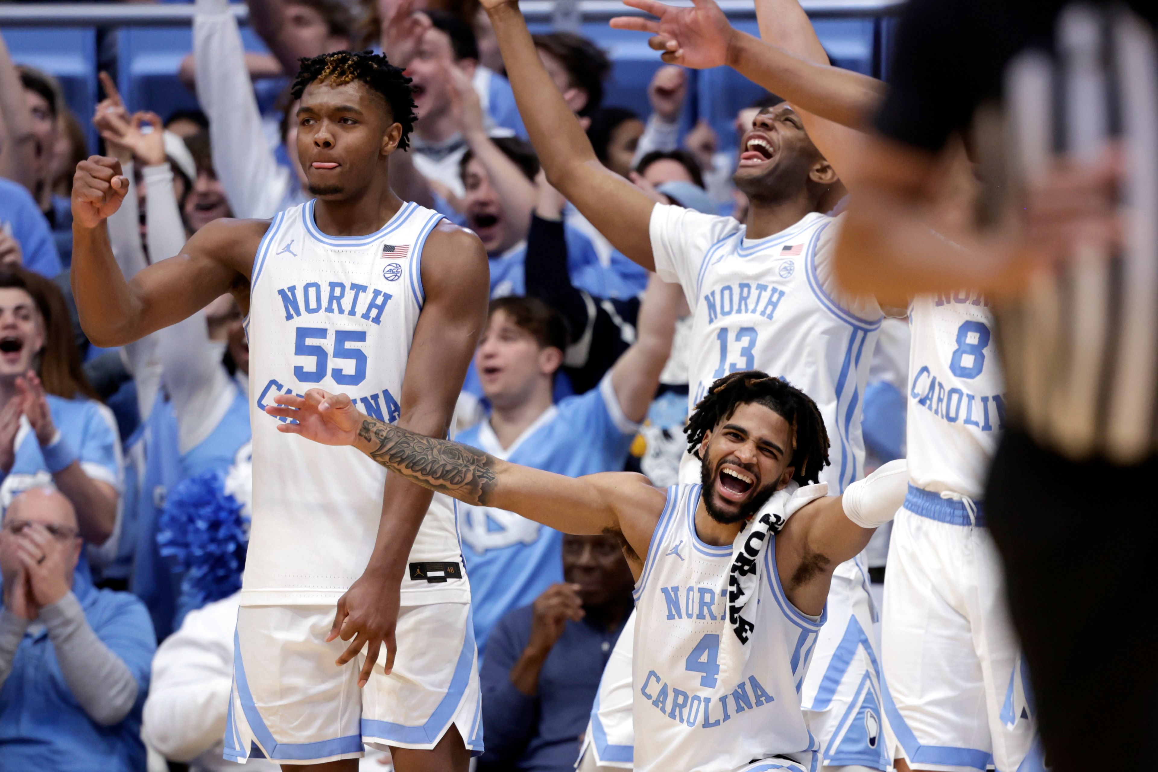 North Carolina forwards Harrison Ingram (55), Jalen Washington (13) and guard RJ Davis (4) celebrate after one of the reserves scored late in the second half of an NCAA college basketball game against Syracuse, Saturday, Jan. 13, 2024, in Chapel Hill, N.C. (AP Photo/Chris Seward)