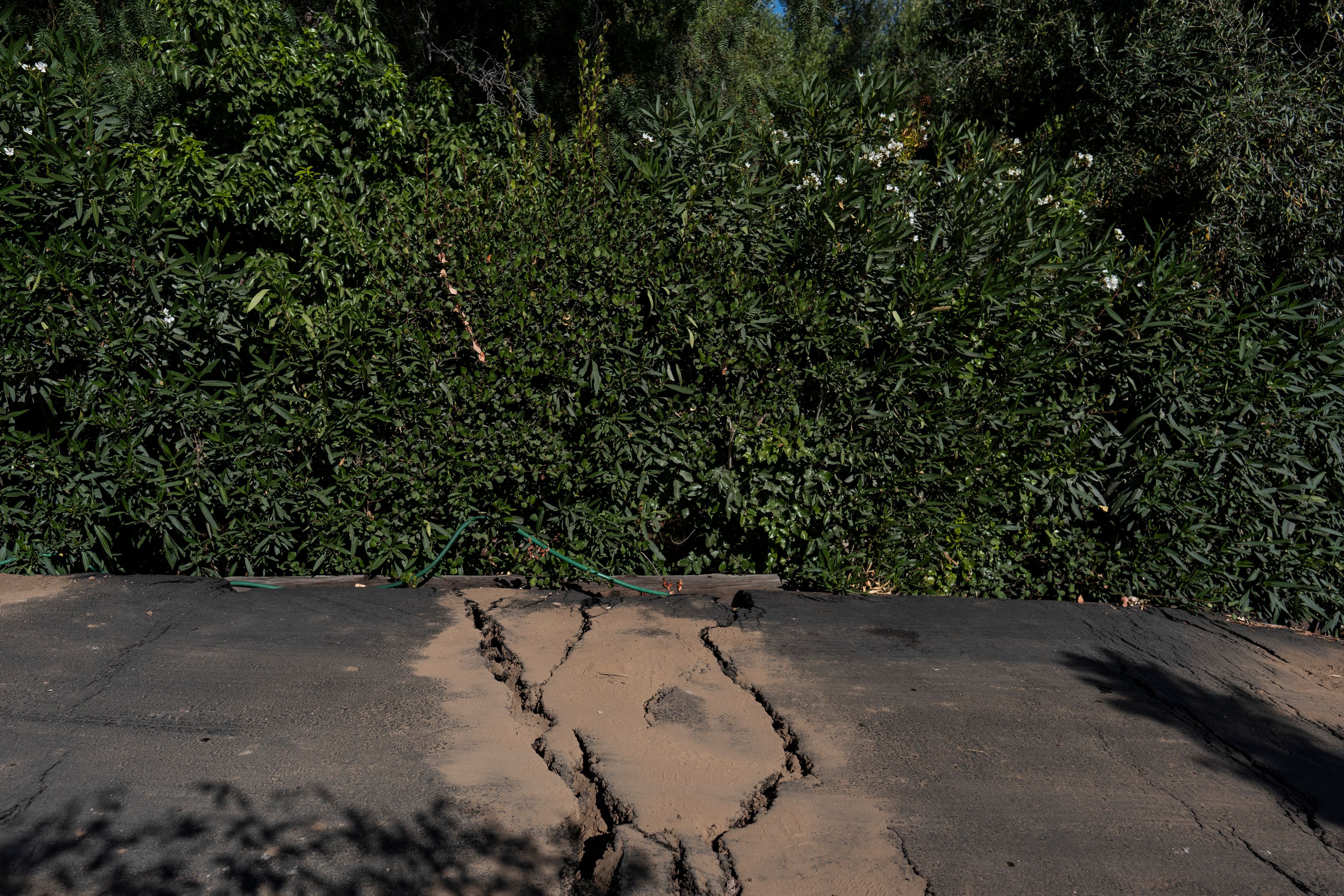 Cracks in the street are filled with dirt in a neighborhood affected by ongoing landslides in Rancho Palos Verdes, Calif., Tuesday, Sept. 3, 2024.