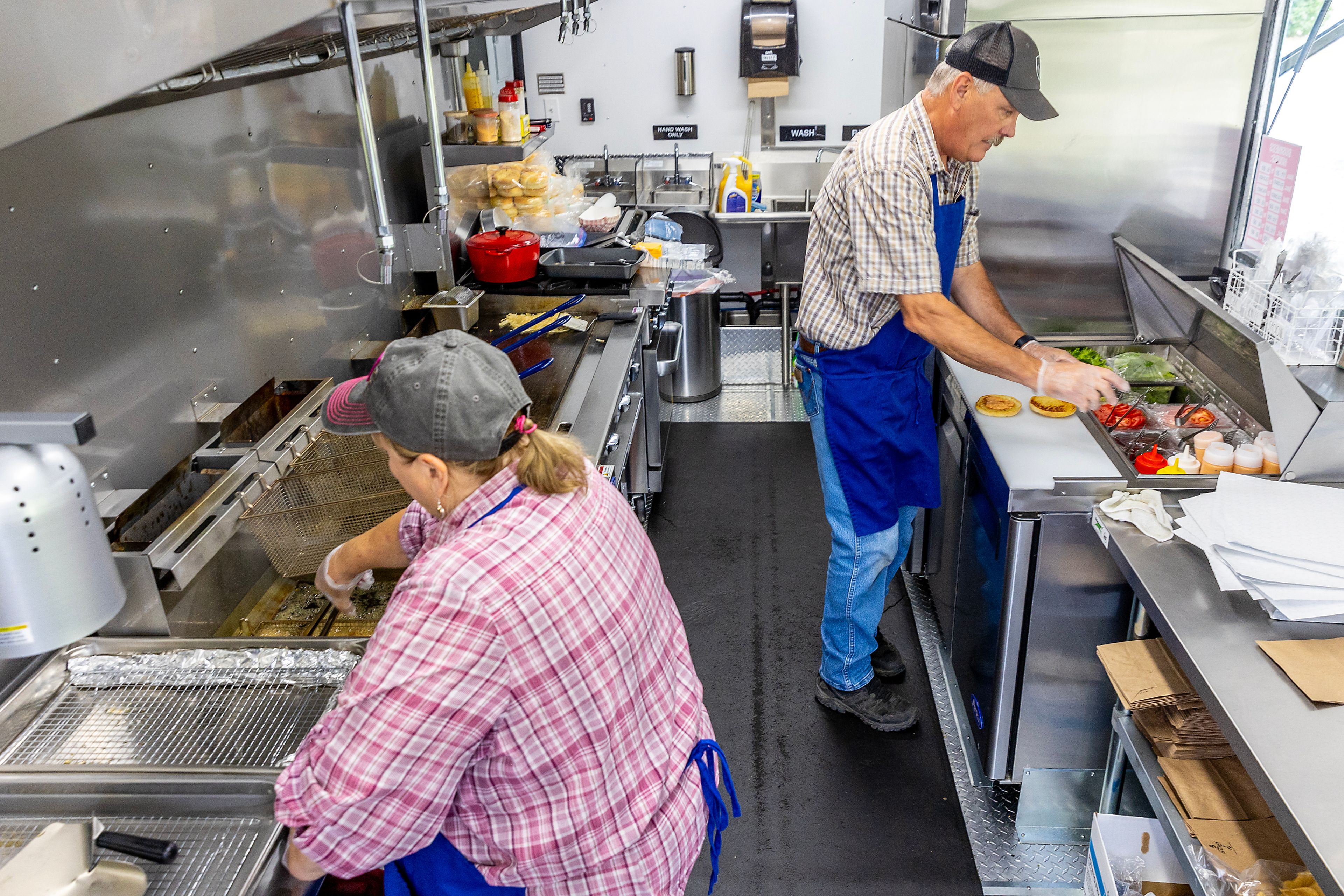 Bob and Pam Swantstrom prepare food at their food truck Flat Top Burgers outside The Hilltop on Friday, Aug. 9, in Grangeville.