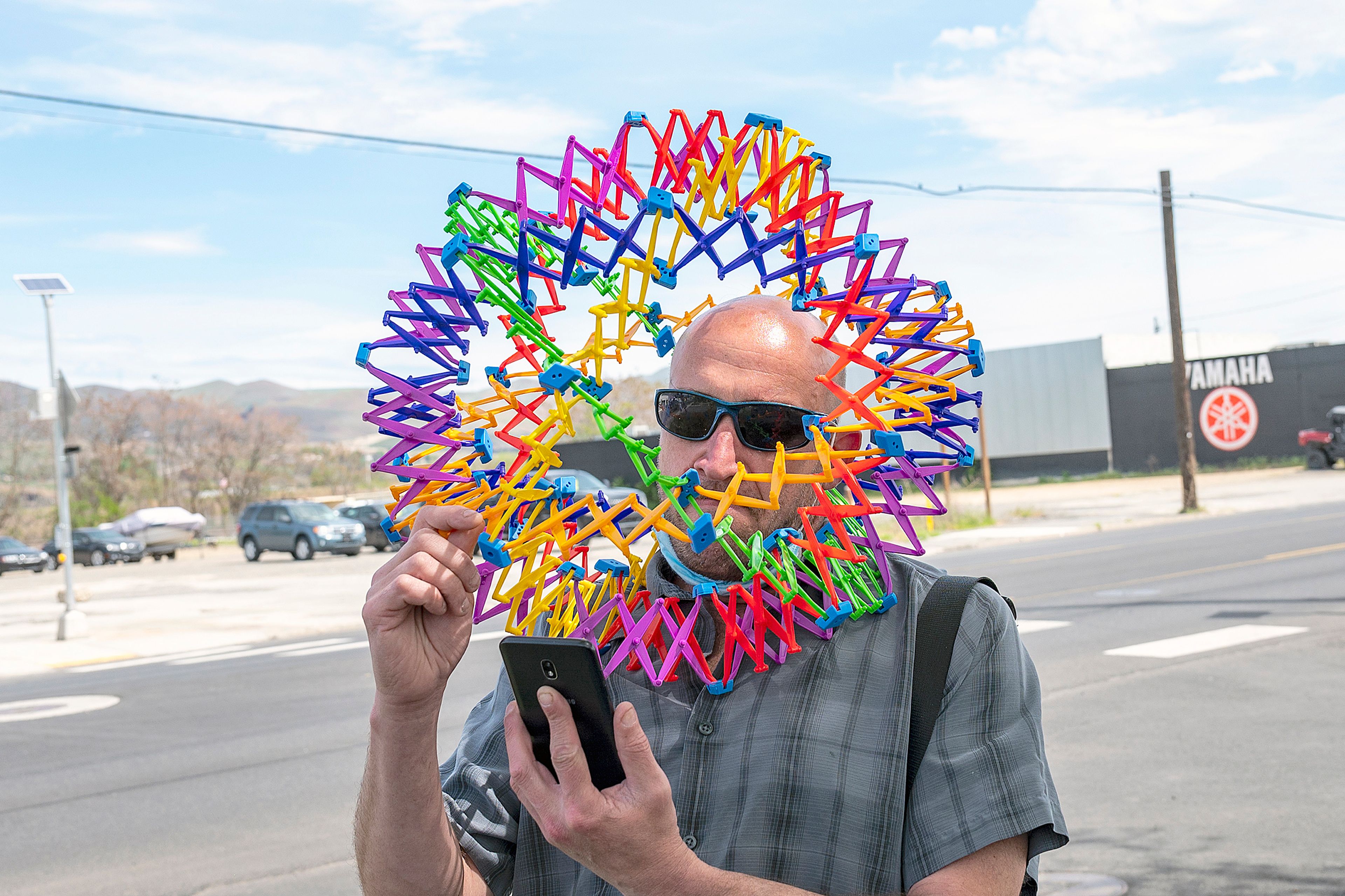 Aaron “Pee Wee” Jones, 48, of Asotin, adjusts the Hoberman Sphere he was wearing around his head to check the time on his phone because he was on his way to a meeting while walking down Main Street in Lewiston on Wednesday afternoon. “I just like to make people laugh and smile,” Jones said. “If everyone was out there making people smile and laugh the world would be a better place.”