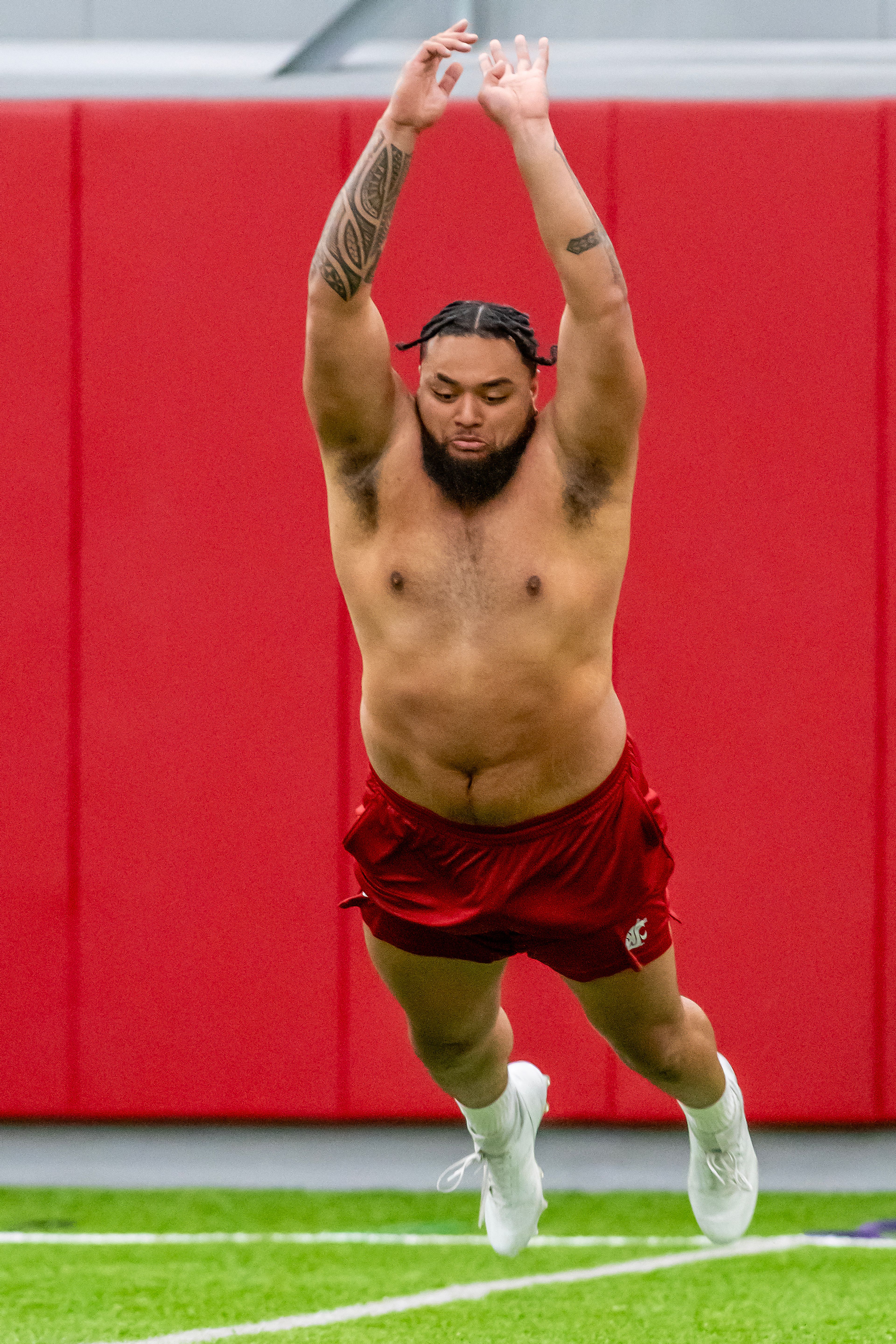 Washington State offensive lineman Esa Pole leaps forward in the broad jump test during WSU's Pro Day on Friday in Pullman.