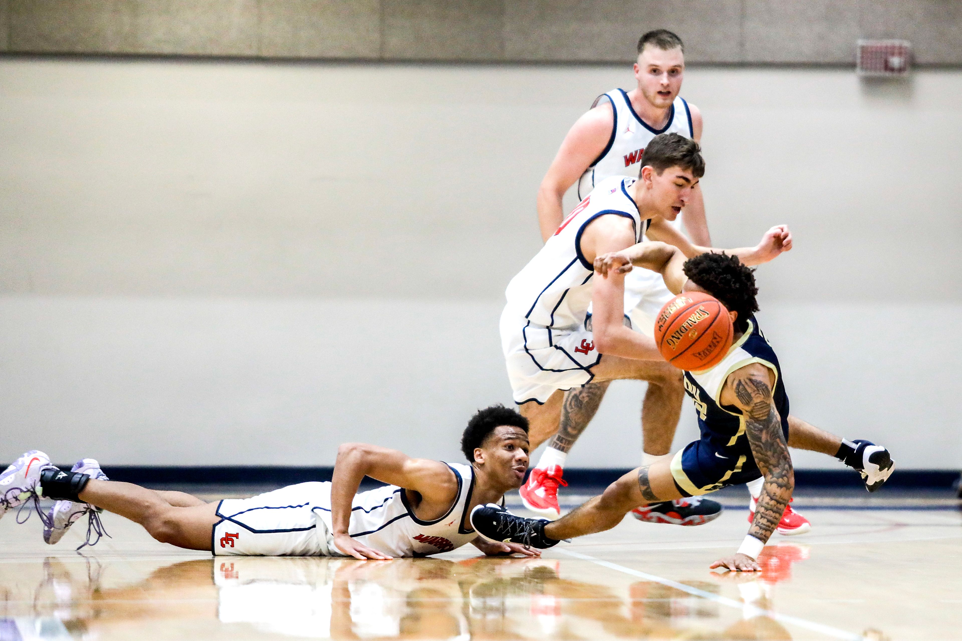 Eastern Oregon guard Andre Huddleston is tripped up by Lewis-Clark State guard Davian Brown as he goes after a loose ball during a Cascade Conference game Friday at Lewis-Clark State College.