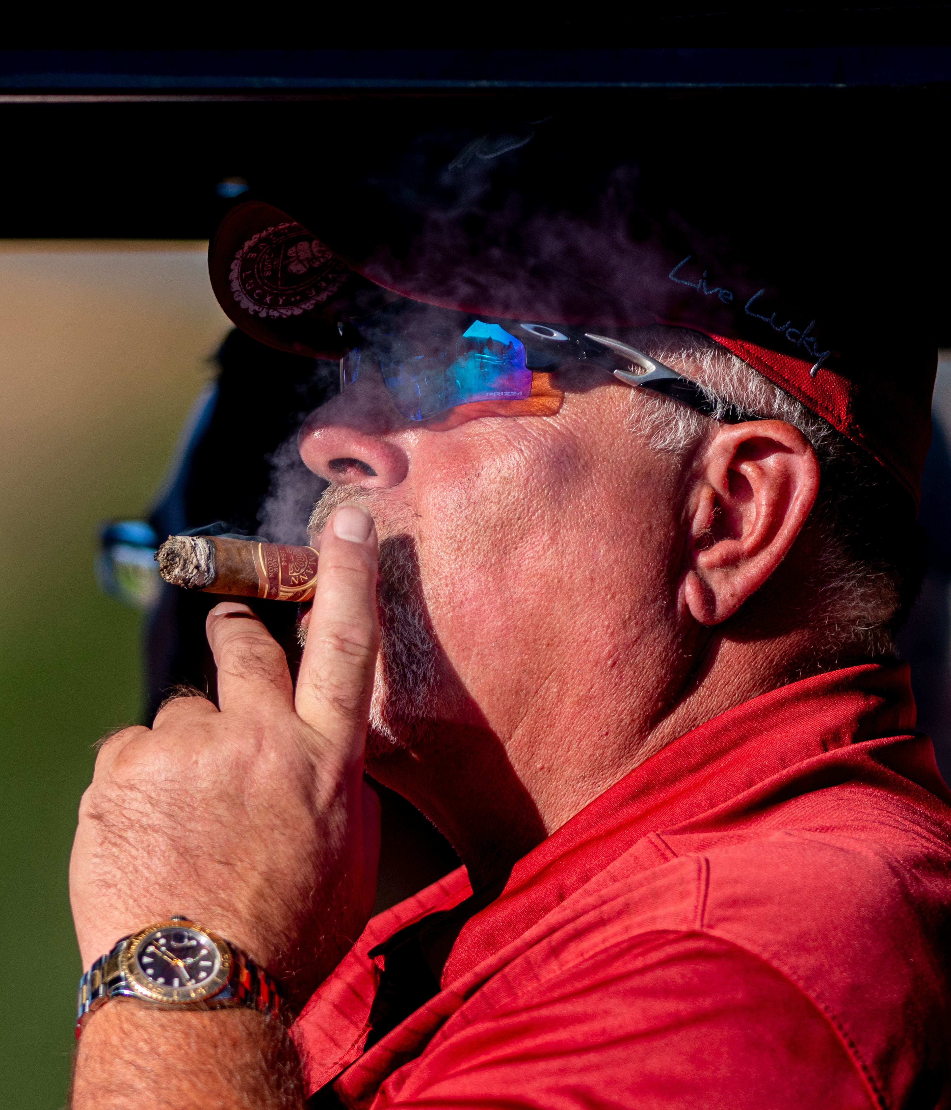 A golf enthusiast enjoys a cigar Monday while watching the 2022 Sole Survivor golf tournament at the Lewiston Golf and Country Club.