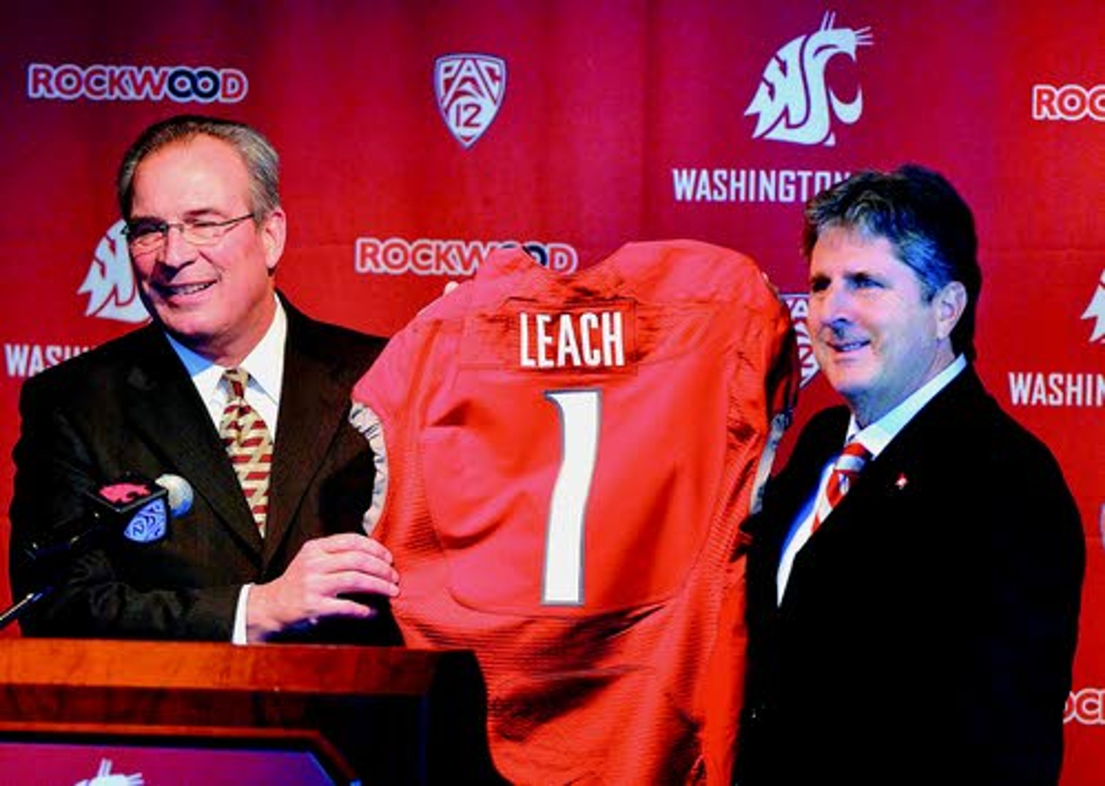 Washington State athletic director Bill Moos (left) presents new
football coach Mike Leach with a Cougar jersey during a news
conference at Pullman. Leach was officially introduced during a
festive gathering at the Compton Union Building on Tuesday.