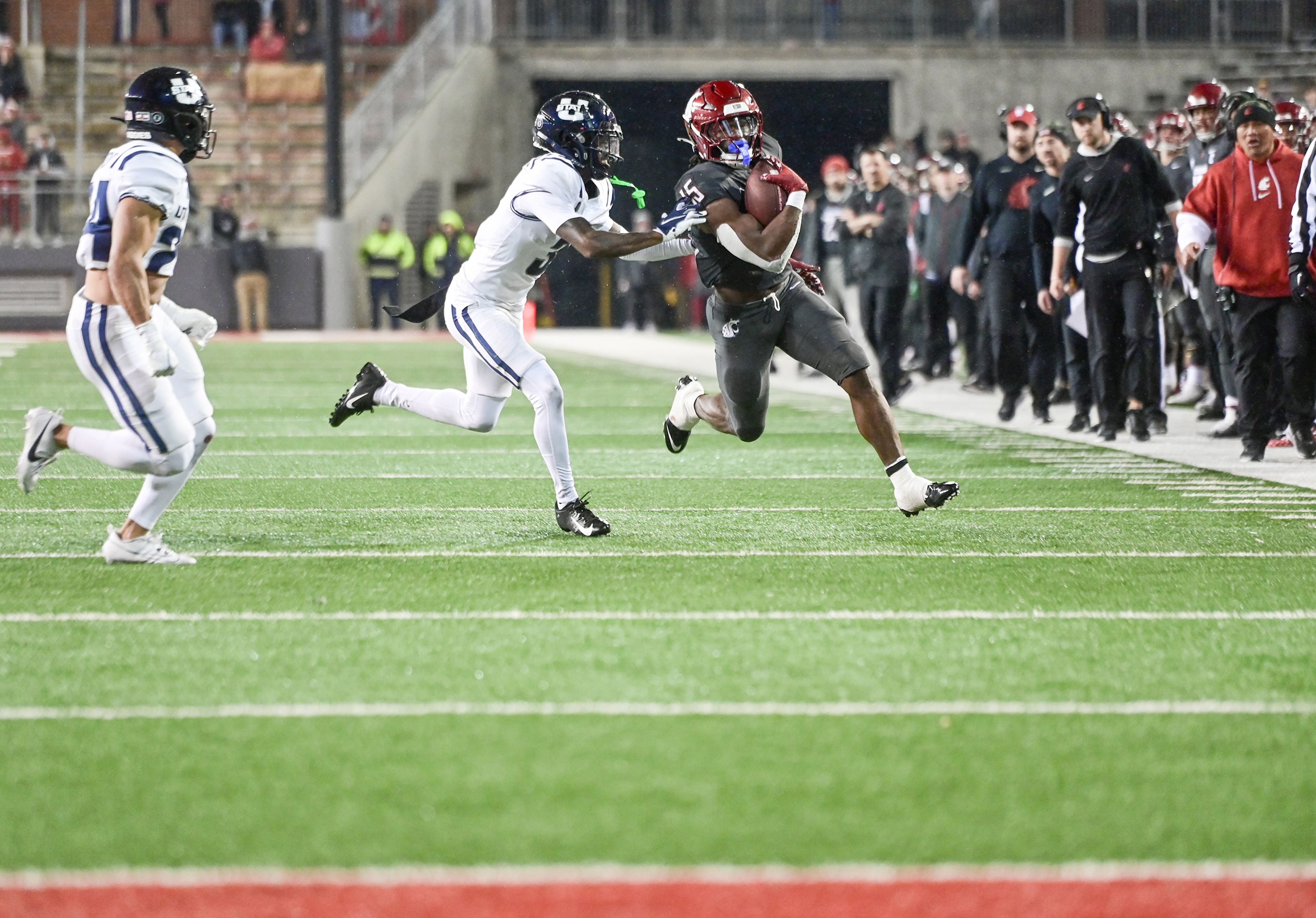 Washington State running back Djouvensky Schlenbaker (15) carries the ball down the field with pressure from Utah State defenders Saturday at Gesa Field in Pullman.