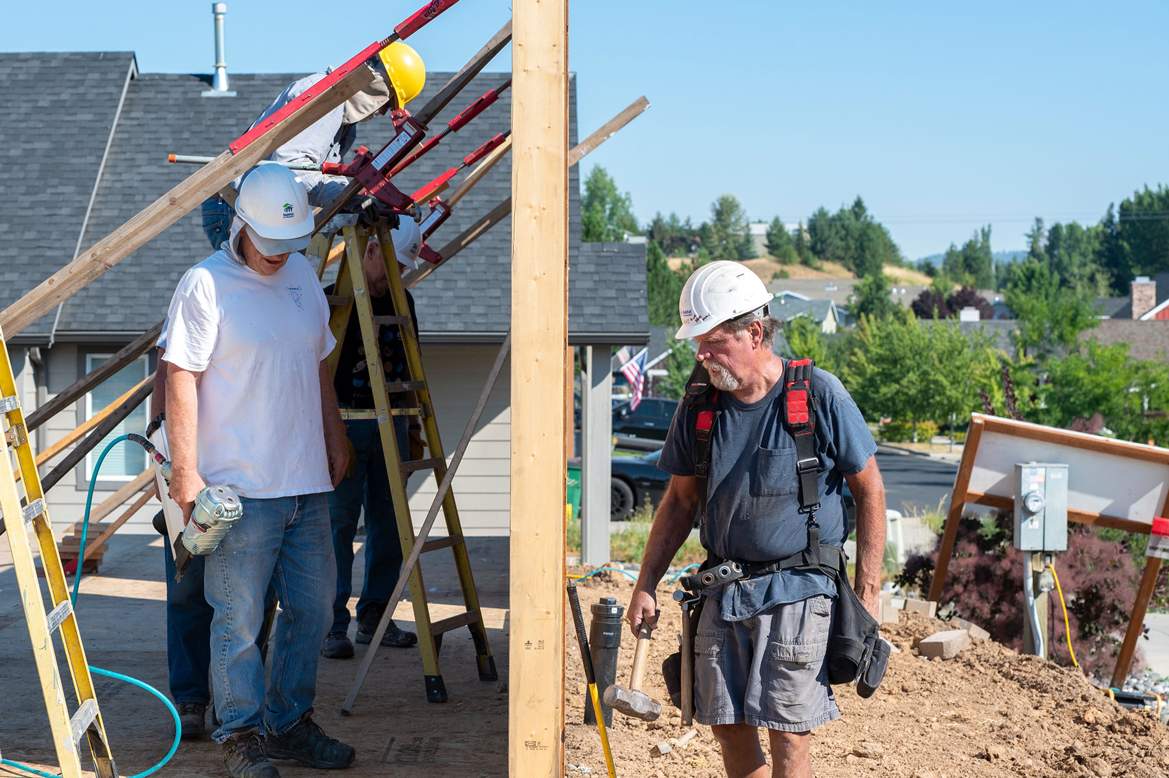 Supervisor Dave Stradley, right, observes one side of the raised wall while constructing a home with volunteers from Palouse Habitat for Humanity in Moscow.