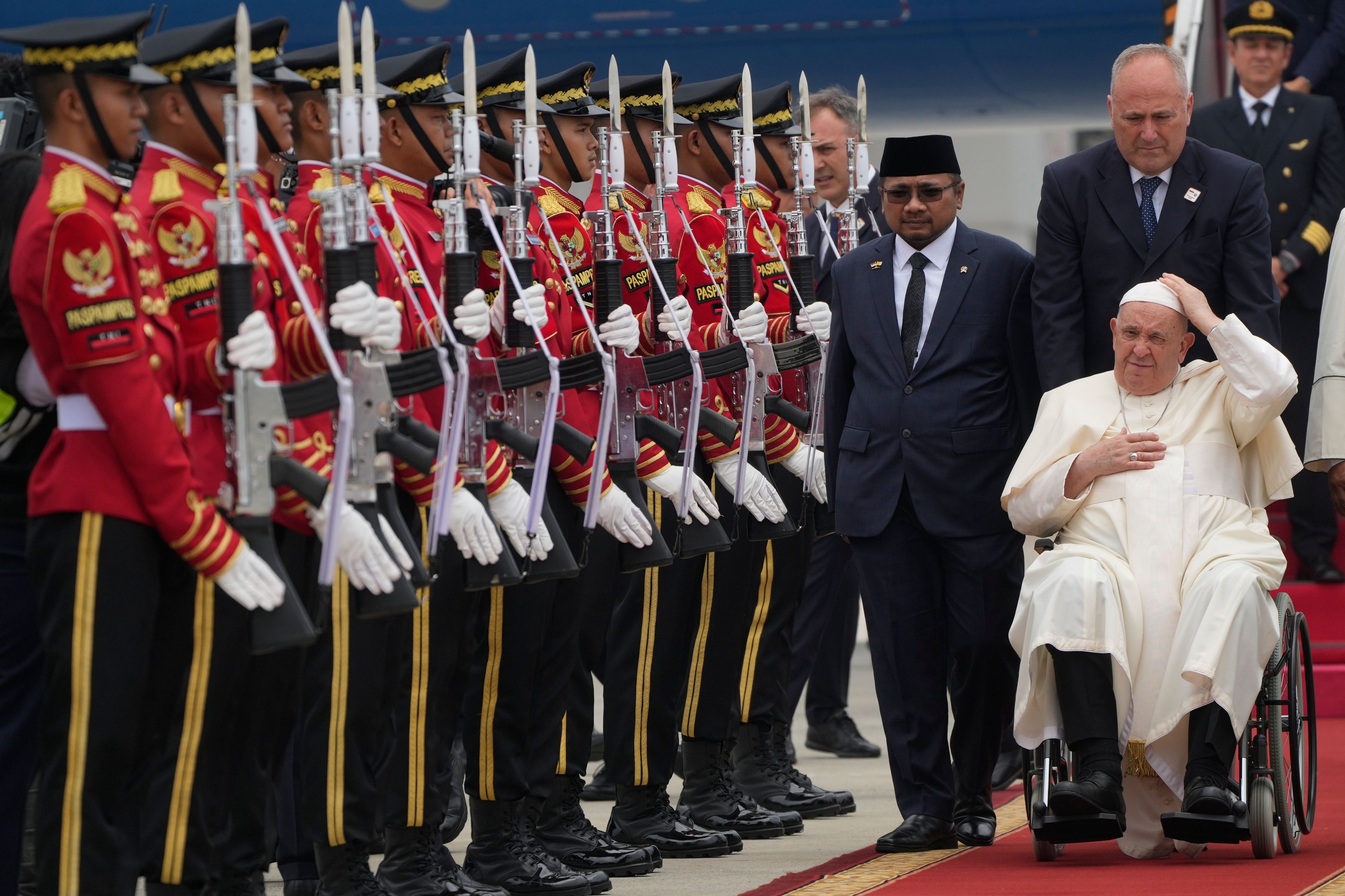 Pope Francis is welcomed by Indonesia's Minister for Religious Affairs Yaqut Cholil Qoumas, center, soon after landing at Jakarta's International airport Soekarno Hatta, Tuesday, Sept. 3, 2024. Pope Francis arrived in Indonesia on Tuesday at the start of the longest trip of his pontificate, hoping to encourage its Catholic community and celebrate the tradition of interfaith harmony in a country with the world's largest Muslim population.