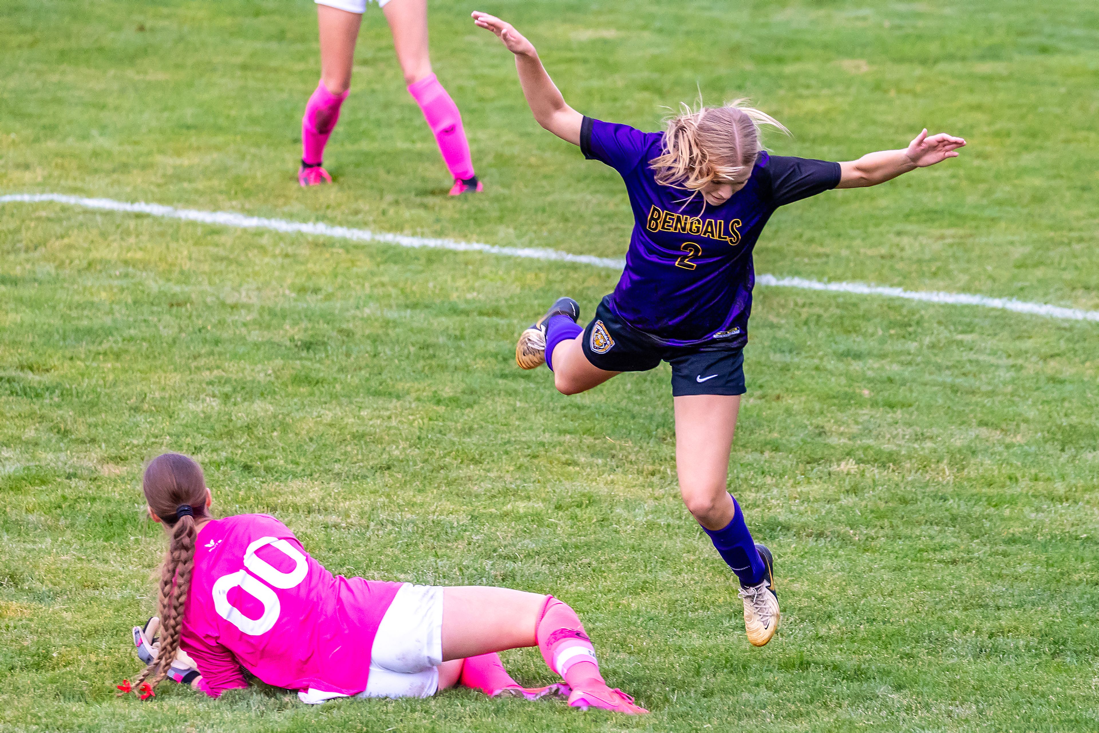 Lewiston�s Avery Lathen leaps over Sandpoint goalkeeper Lilliana Brinkmeier as she grabs the ball in the 5A Inland Empire League District Championship Wednesday at Walker Field in Lewiston.,