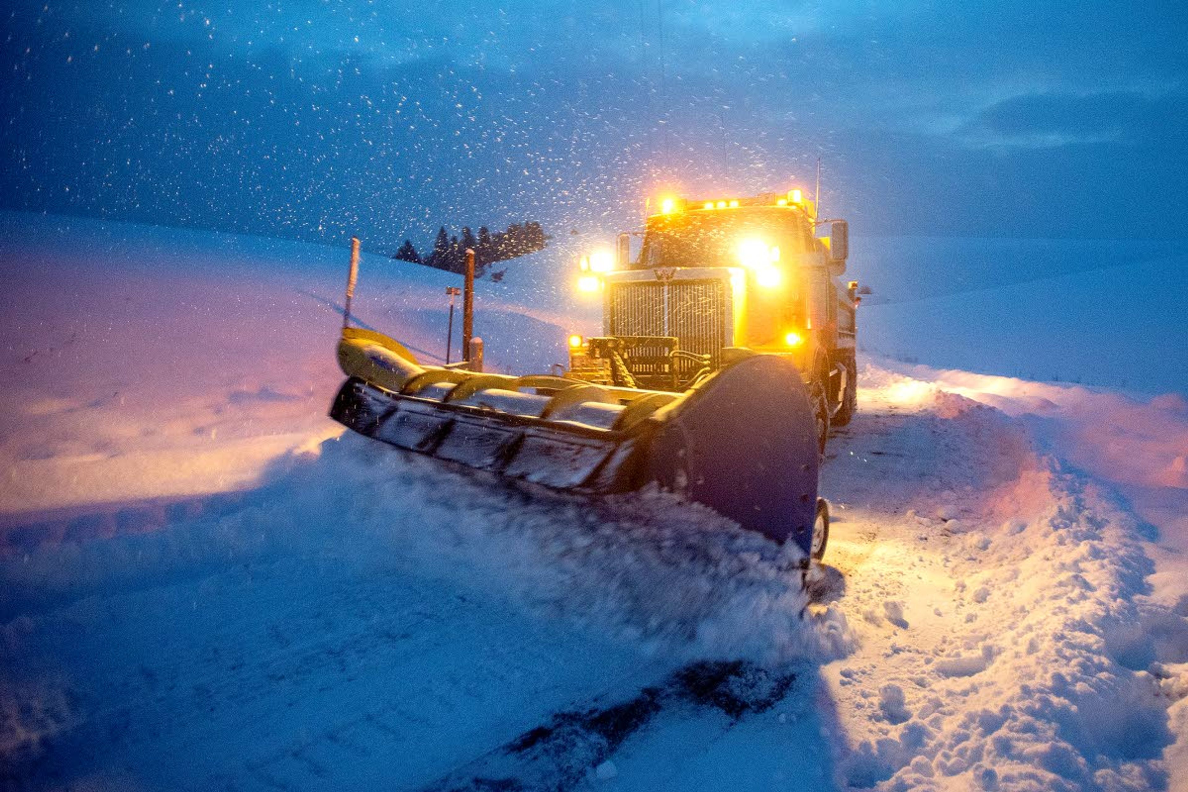 Battling ice underneath the fresh powder, Cody Bailey, 33, makes his way up a steep hill as he clears off Airport Road at the break of dawn Wednesday. Bailey, who has been working with the South Latah Highway District since last April, started his day around 3:30 a.m. without knowing for sure when his workday would end. Bailey was one of eight equipment operators working to clear the recent snowfall in southern Latah County.