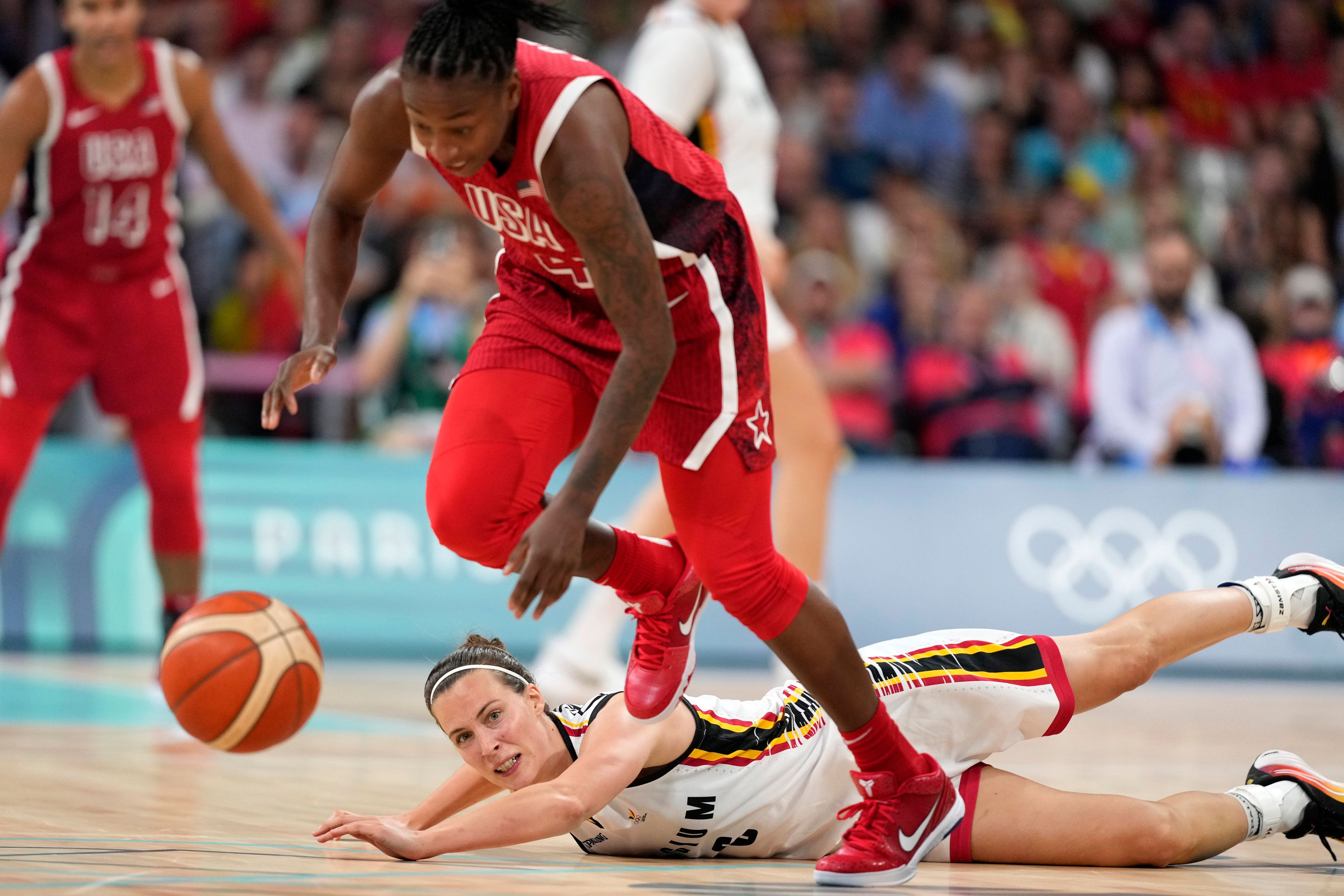 United States' Jewell Loyd, top, and Belgium's Antonia Delaere go after a loose ball during a women's basketball game at the 2024 Summer Olympics, Thursday, Aug. 1, 2024, in Villeneuve-d'Ascq, France. (AP Photo/Michael Conroy)