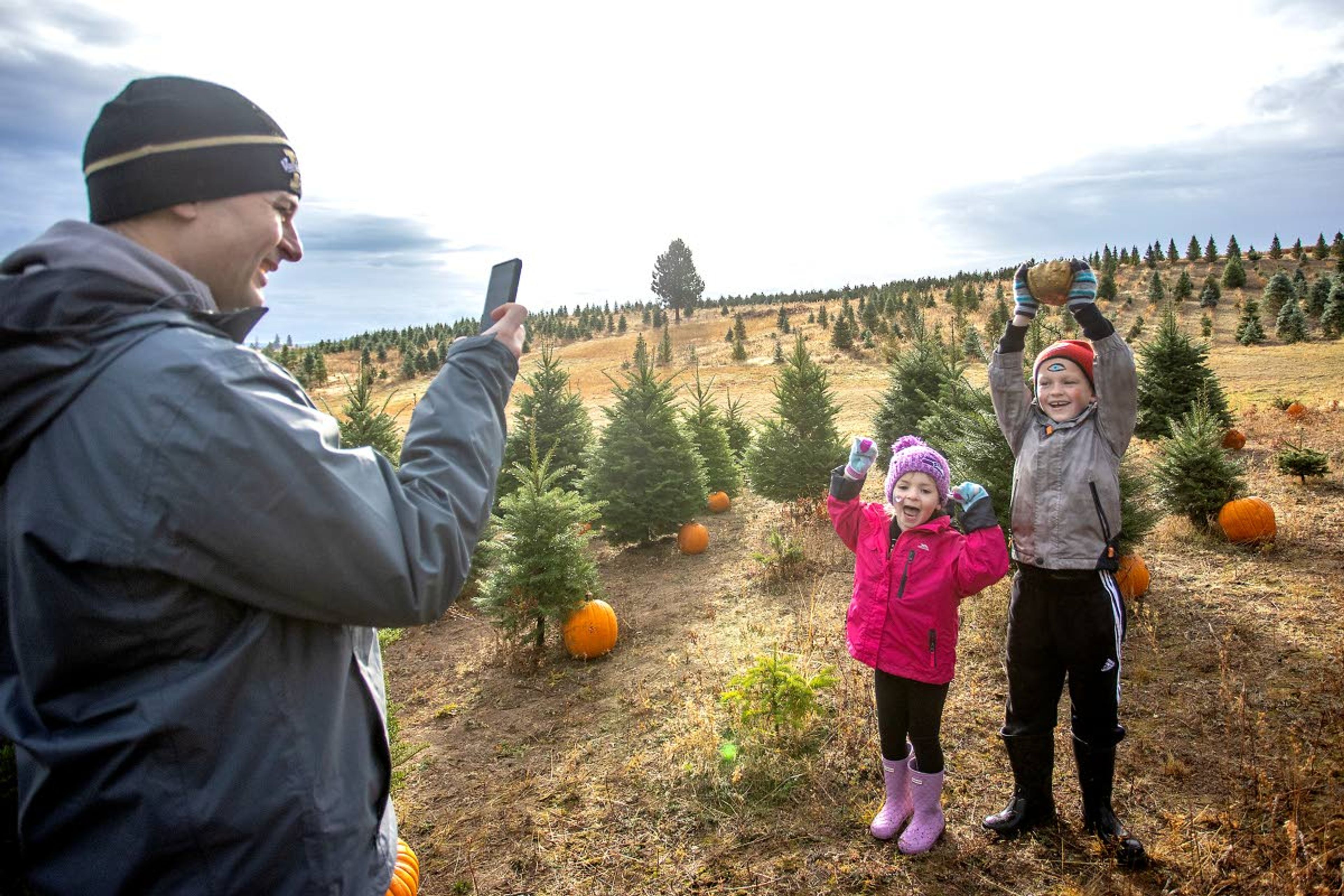 Austin Fletcher, 8, and Kaitlyn Fletcher, 5, celebrate finding one of five golden gourds hidden among the trees as their dad Rory Fletcher, of Moscow, takes a photo at the 6th annual Spring Valley Tree Farm Pumpkin Hunt outside Troy on Saturday.