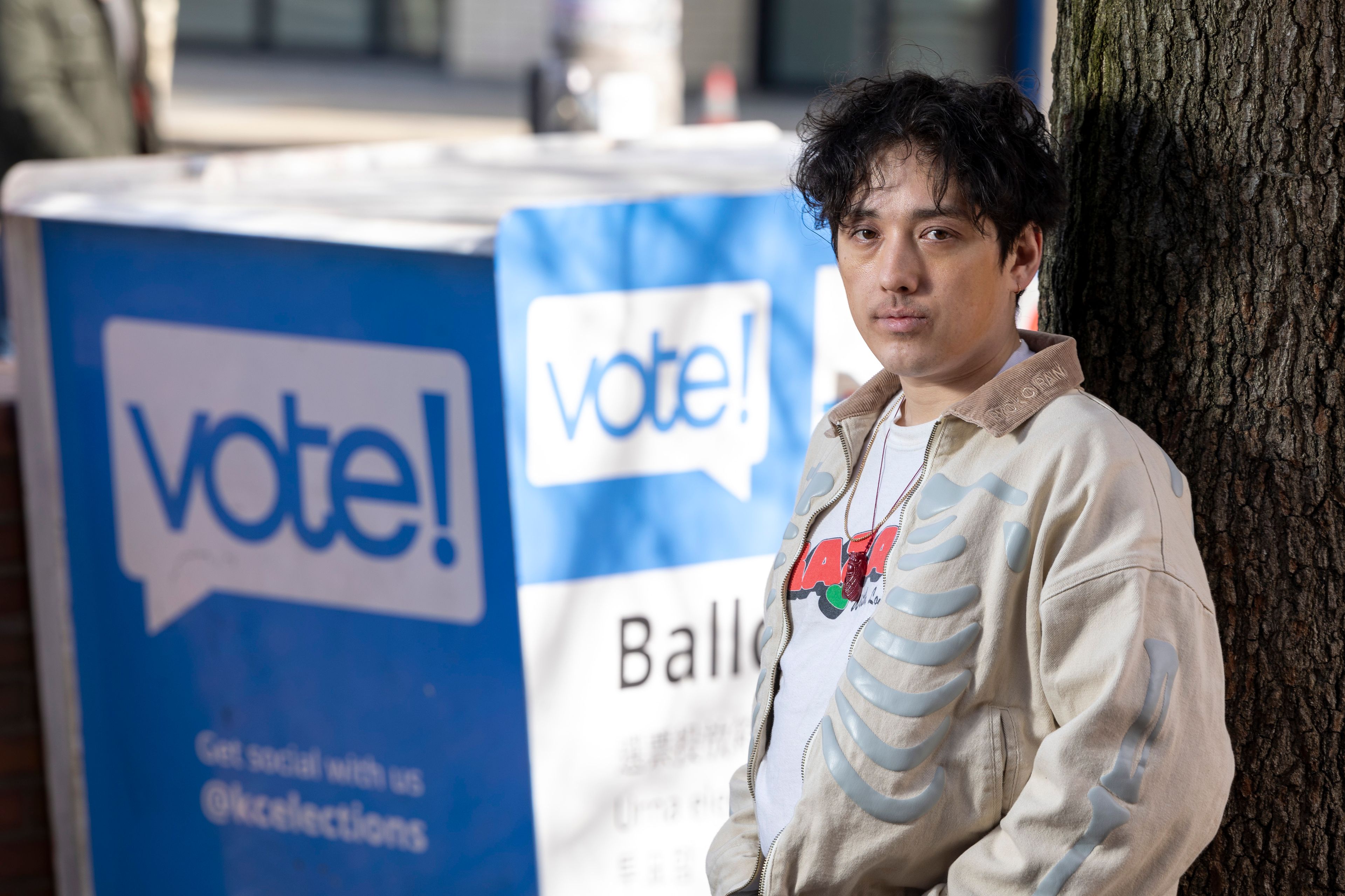 Kenji Takada-Dill, 30, of Seattle, poses for a photo next to a drop box where voters can drop off ballots in the vote-by-mail state Wednesday, March 13, 2024, in Seattle. (AP Photo/Jason Redmond)