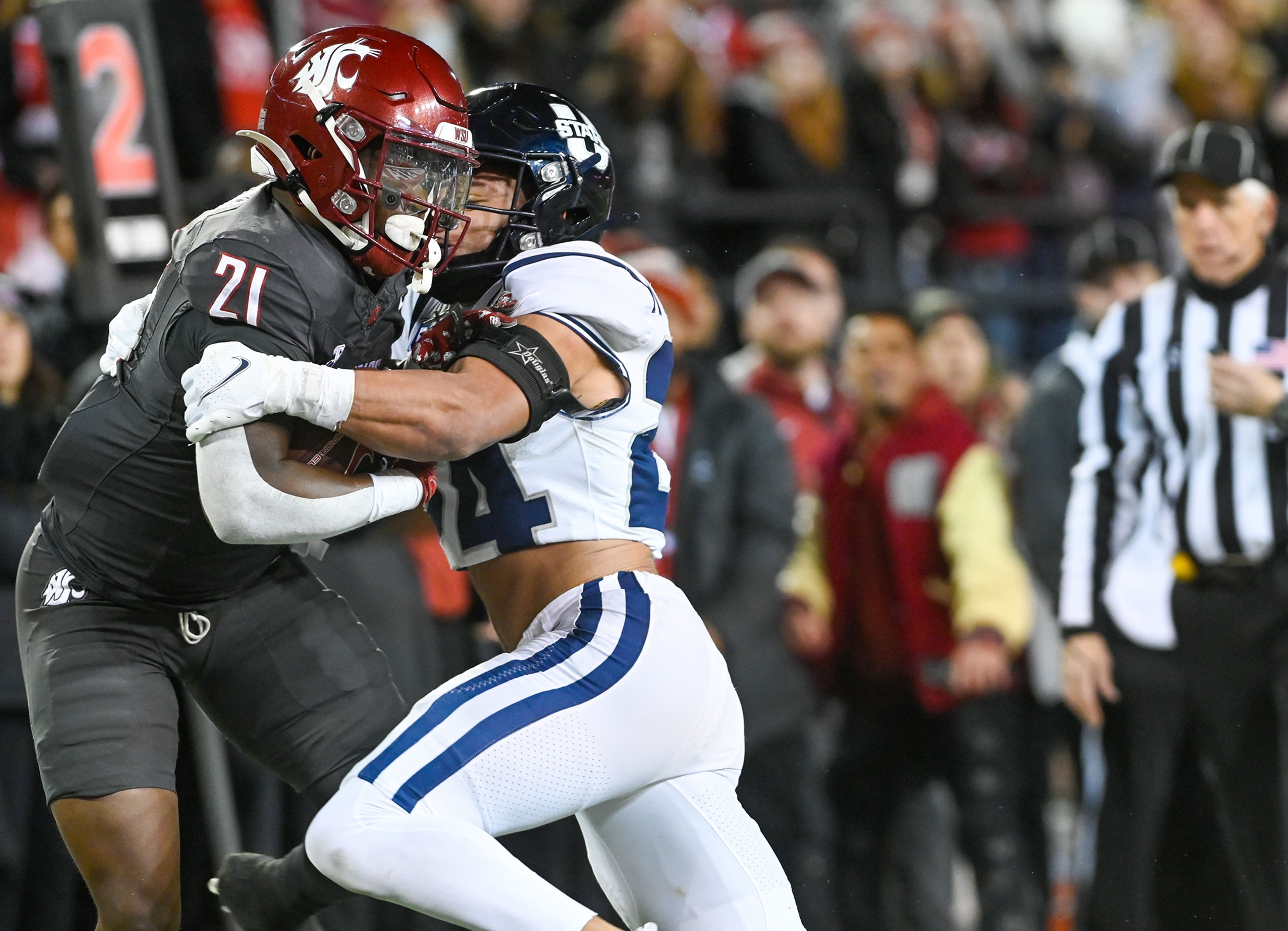 Washington State running back Wayshawn Parker (21) collides with Utah State safety Jordan Vincent (24) after Parker completed a pass Saturday at Gesa Field in Pullman.