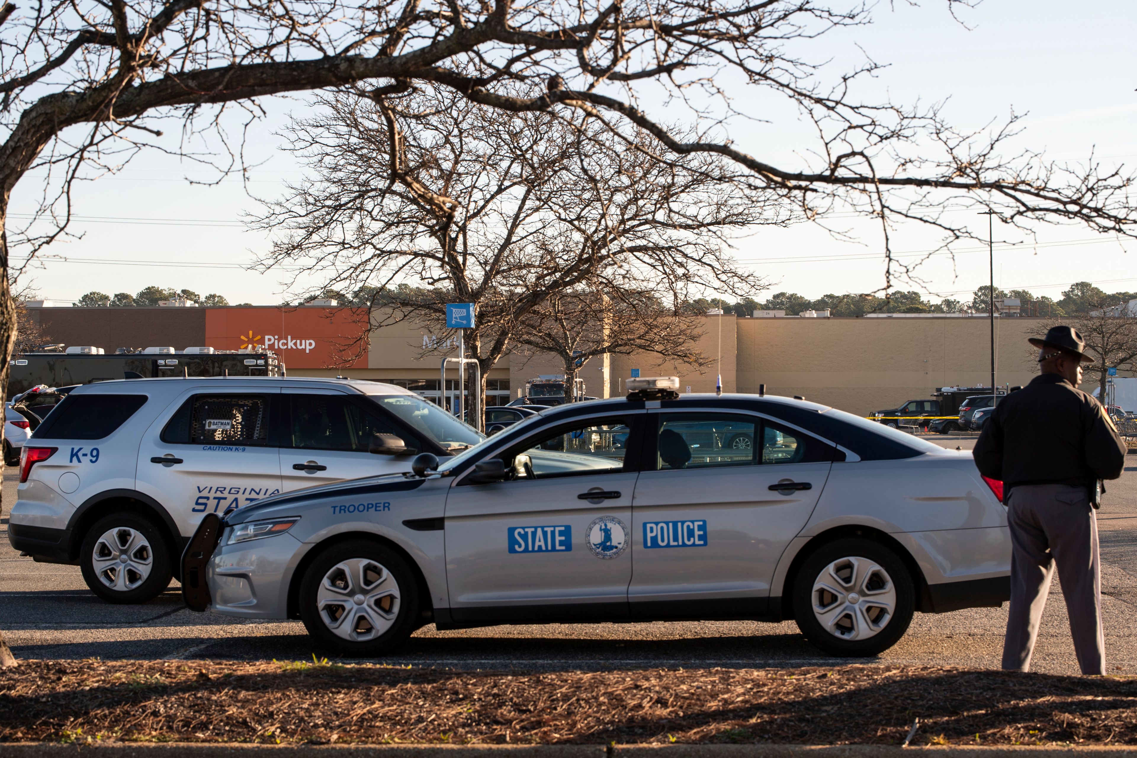 Police wait outside of a Walmart in Chesapeake, Va. on Wednesday, Nov. 23, 2022 where the night before a mass shooting took place. Authorities and witnesses say a Walmart manager opened fire on fellow employees in the break room of the store. (Billy Schuerman/The Virginian-Pilot via AP)