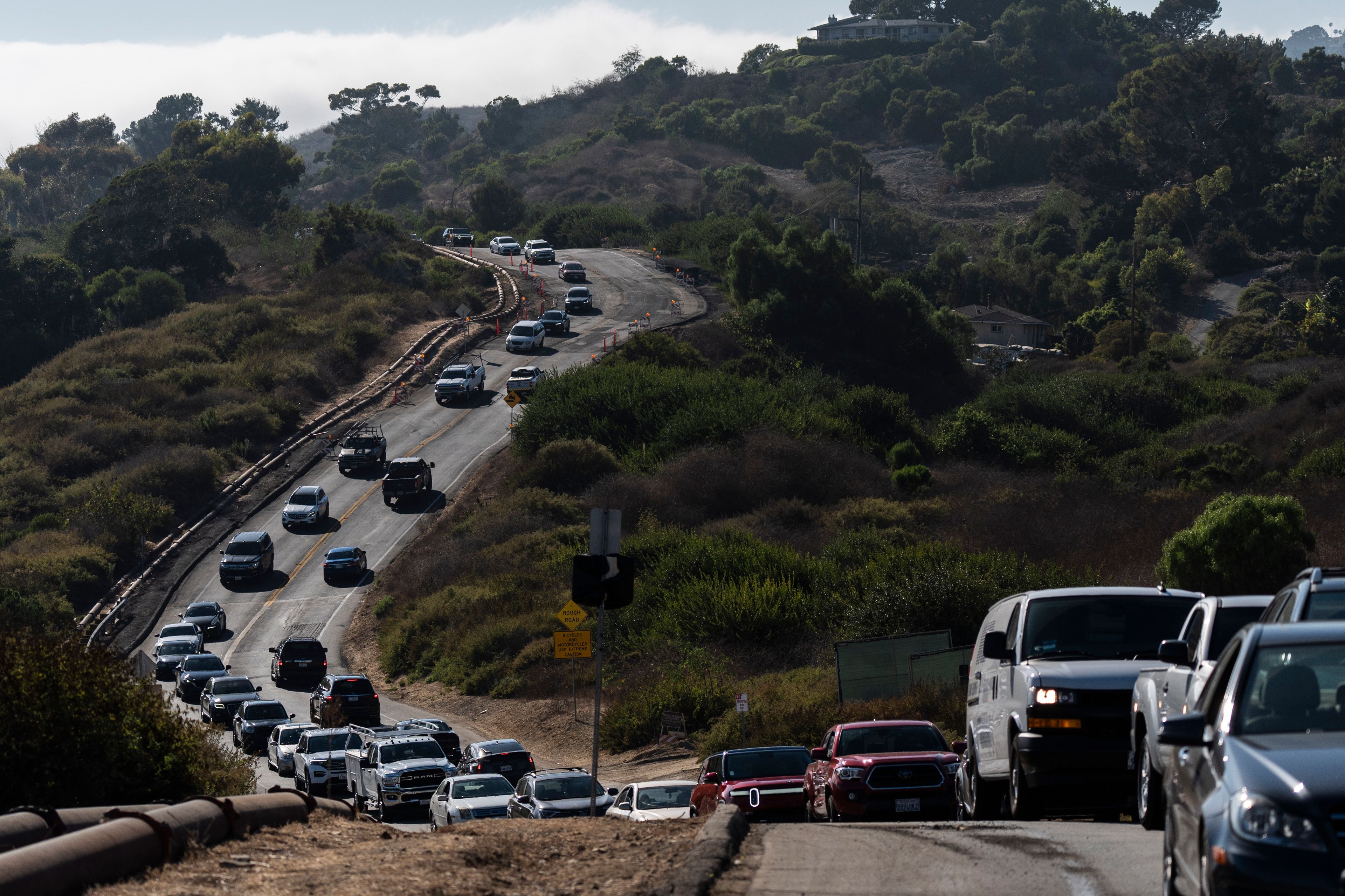 Motorists drive along a section of the road affected by ongoing landslides in Rancho Palos Verdes, Calif., Tuesday, Sept. 3, 2024.