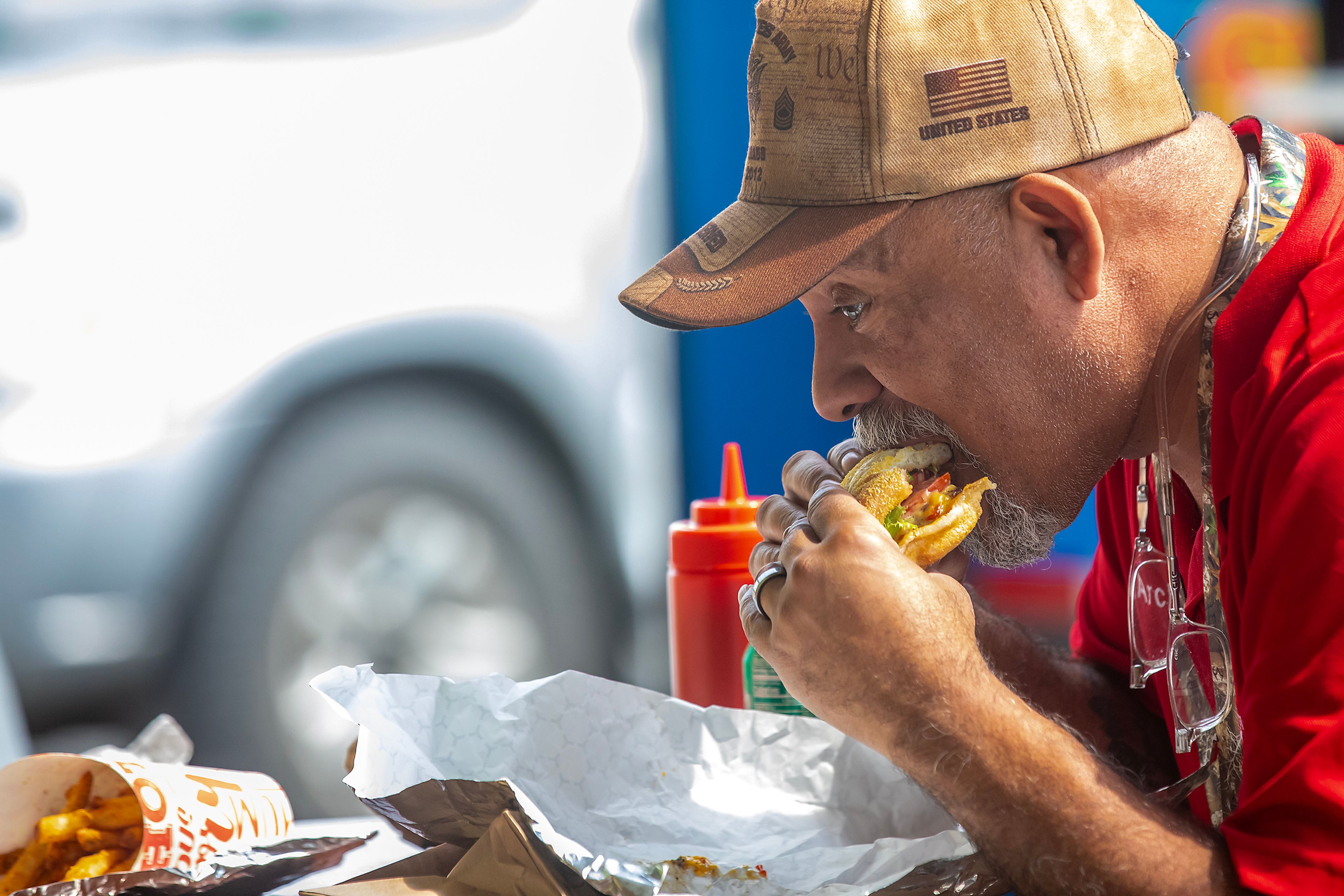 Archi Tirado bites into his lunch from the food truck Flat Top Burgers outside The Hilltop on Friday, Aug. 9, in Grangeville.