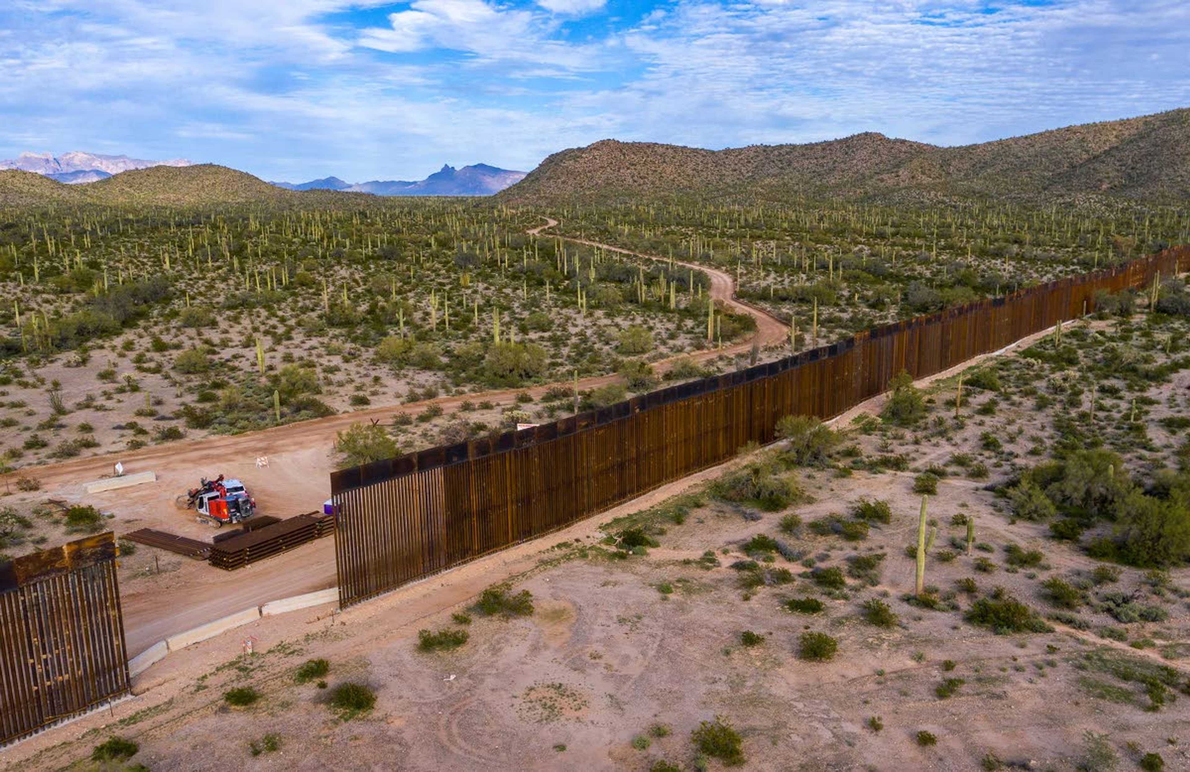 Aerial view from the town of Sonoyta, Mexico, of border wall construction west of Lukeville, Ariz. Crews are widening a border road to 60 feet, uprooting cacti and other plants to make way for a new border wall to replace a vehicle barrier, on February 20, 2020.